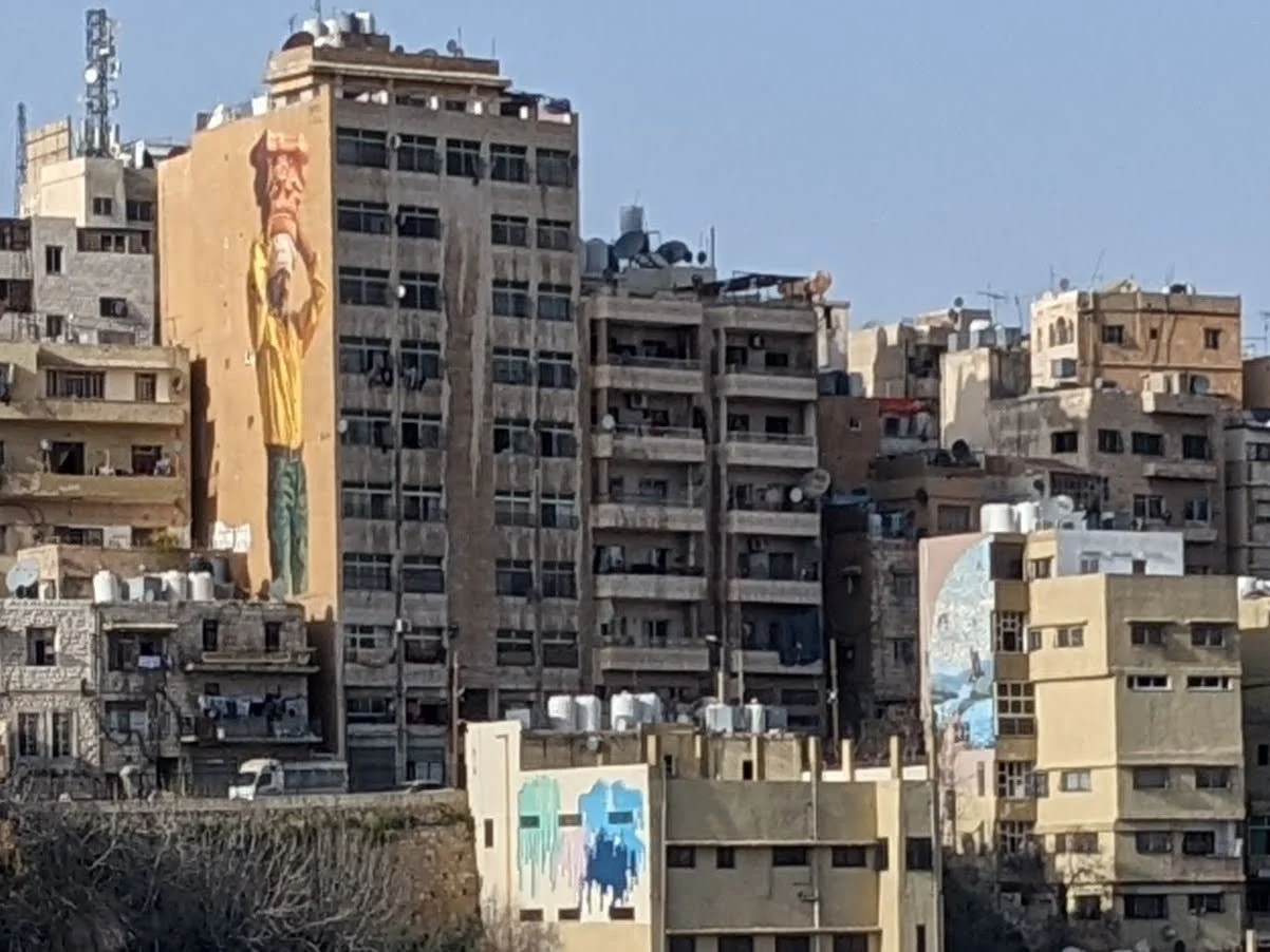 A monumental mural on the side of a building as seen from the Roman Theater. Amman Jordan