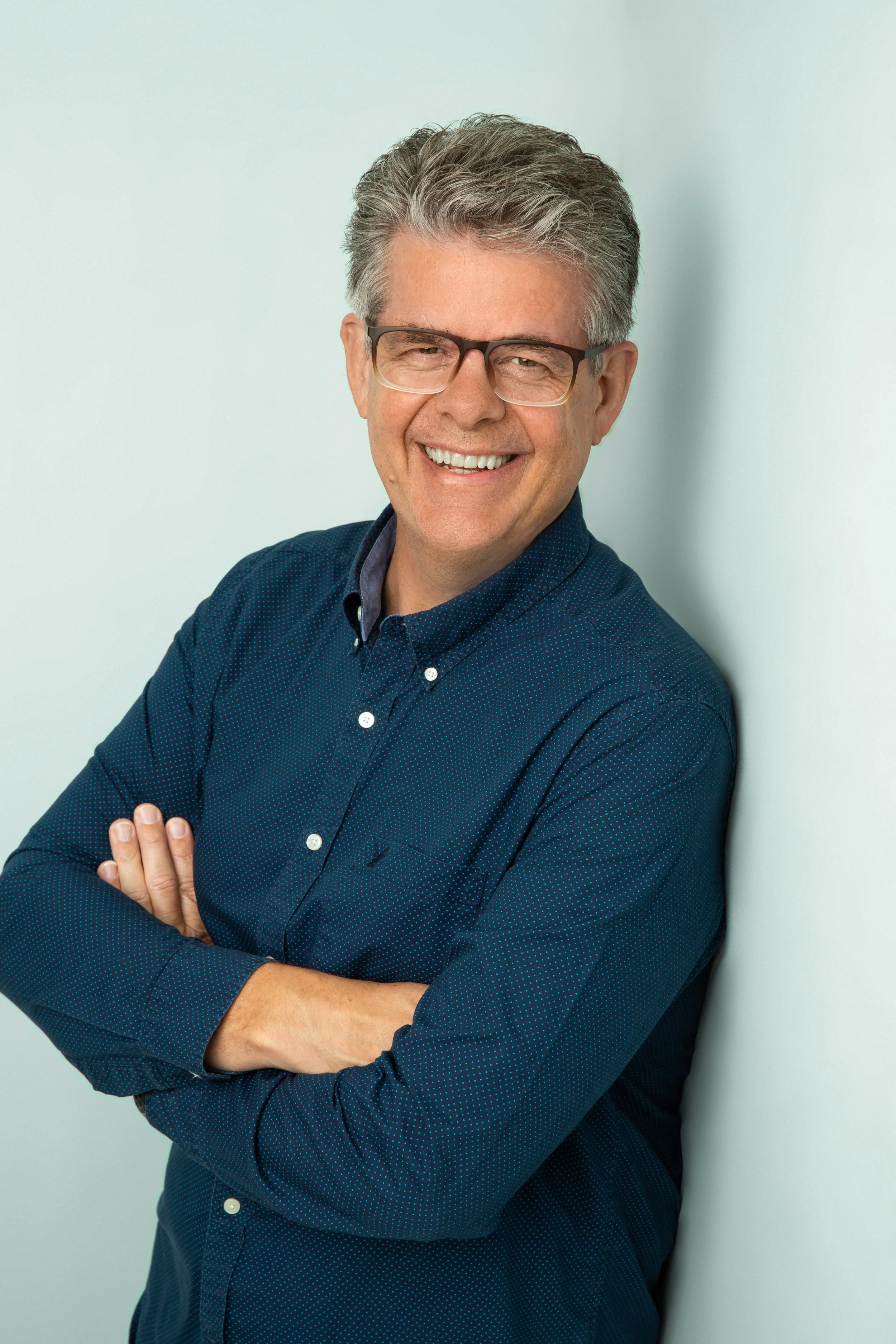 man gray hair glasses blue shirt