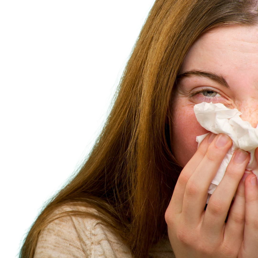 Woman managing seasonal allergy symptoms among flowers