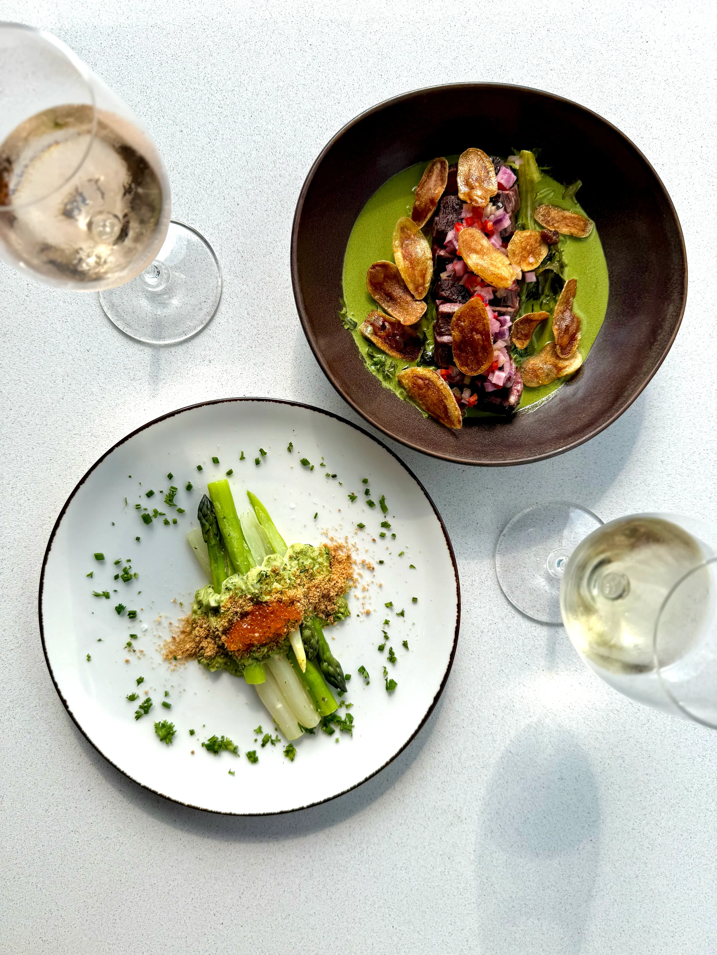 Seasonal farm-to-table dishes at Cork Restaurant in Stowe, Vermont, featuring thoughtfully plated vegetables, fresh ingredients, and natural wine in a bright, modern dining setting.