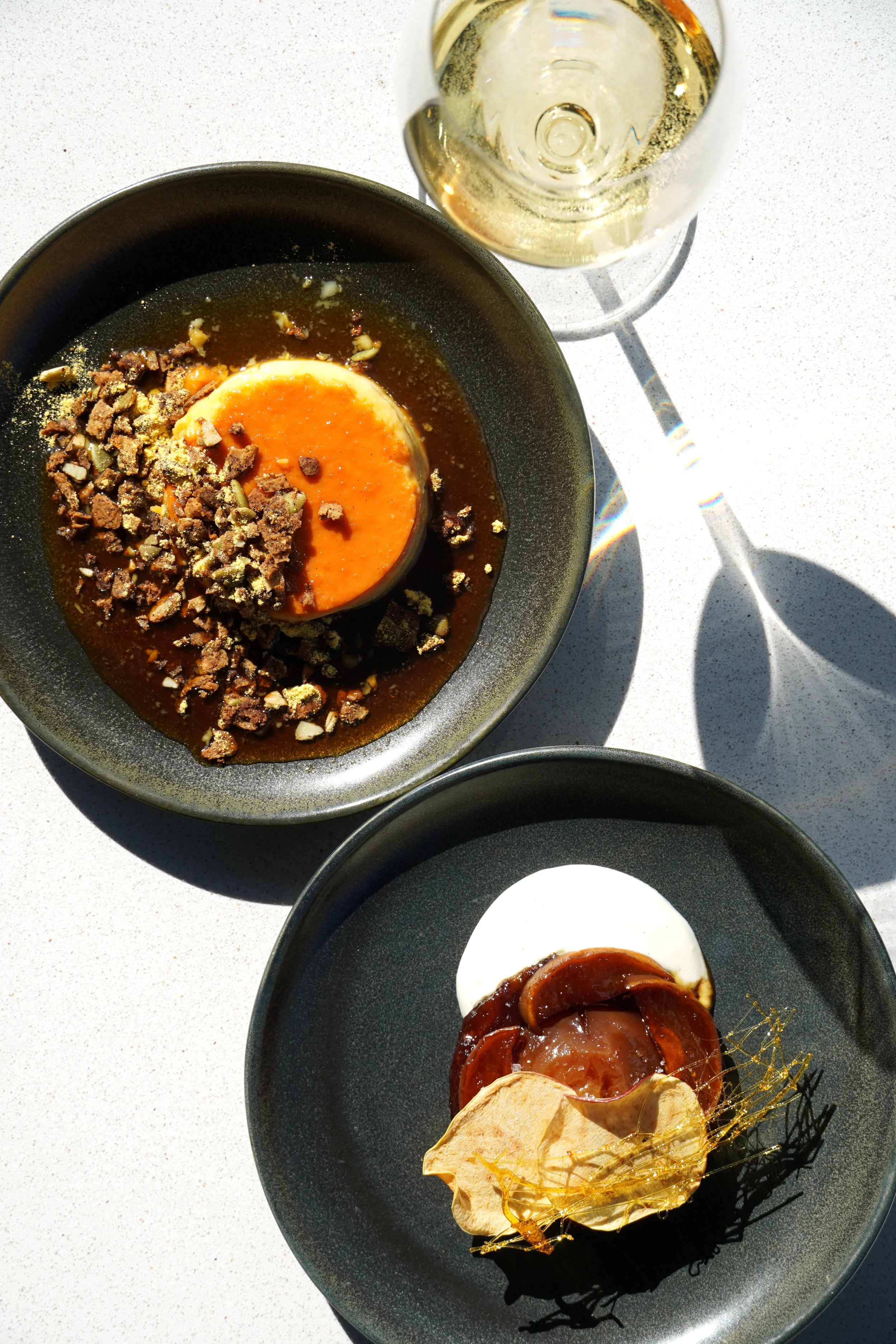 House-made dessert with seasonal accompaniments and wine at Cork Restaurant in Stowe, Vermont, showcasing refined desserts and warm evening ambiance.