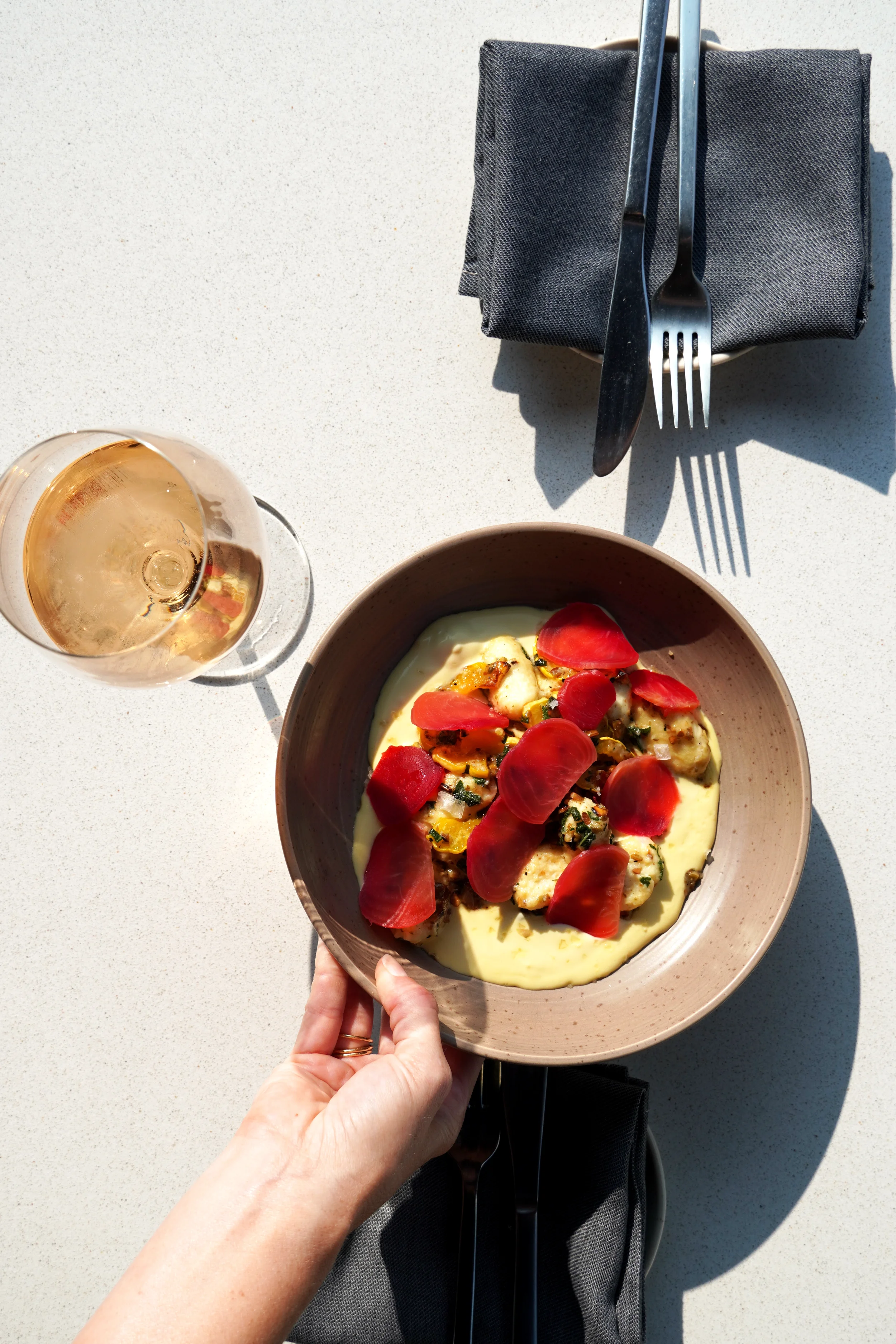 Seasonal farm-to-table dish paired with a glass of natural white wine at Cork Restaurant in Stowe, Vermont, highlighting thoughtful wine pairings and elegant presentation.