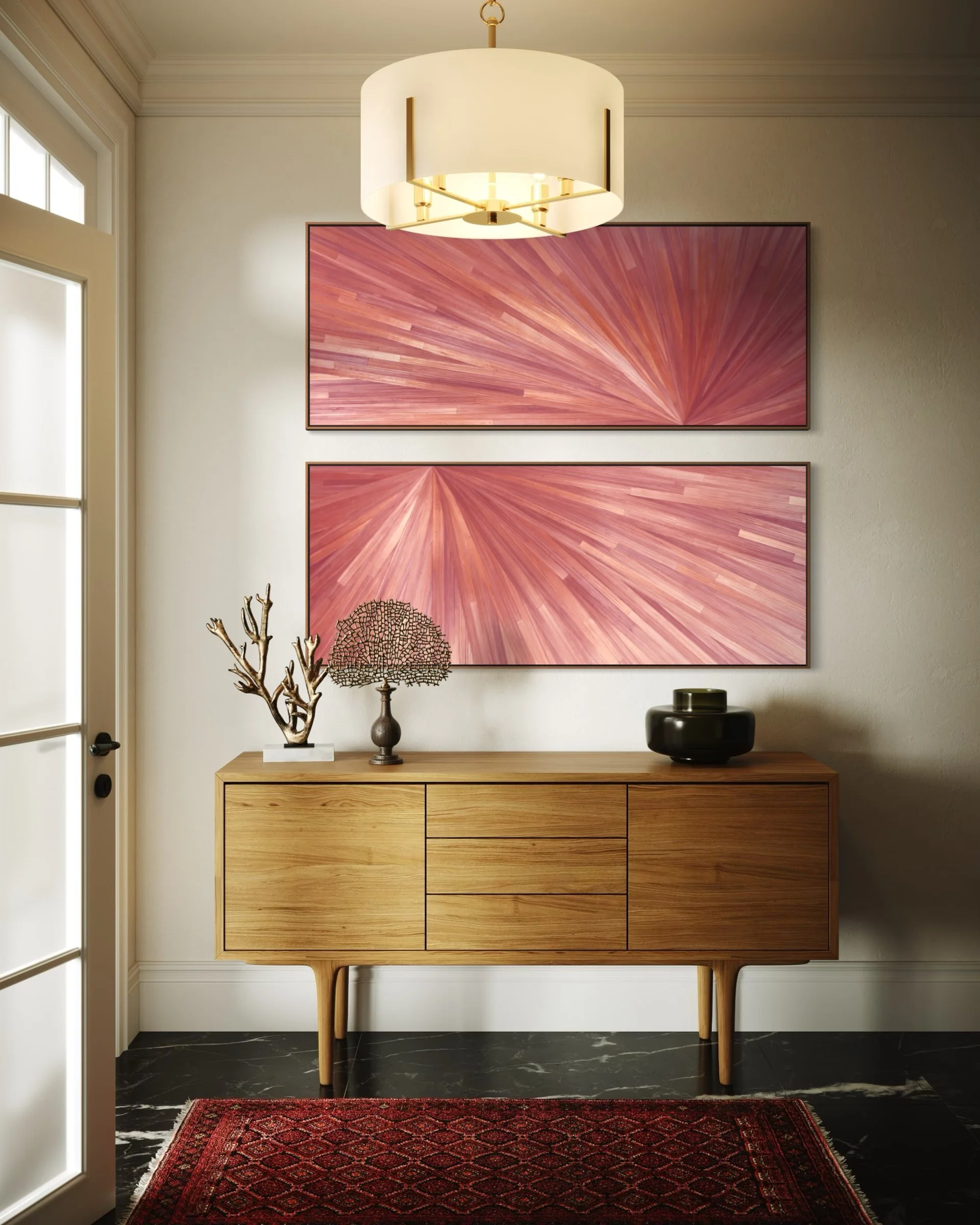 A pair of pink straw marquetry wall art pieces with a radial burst pattern. Hung vertically one above the other, these luminous panels add refined texture and organic warmth to a sophisticated entryway. 