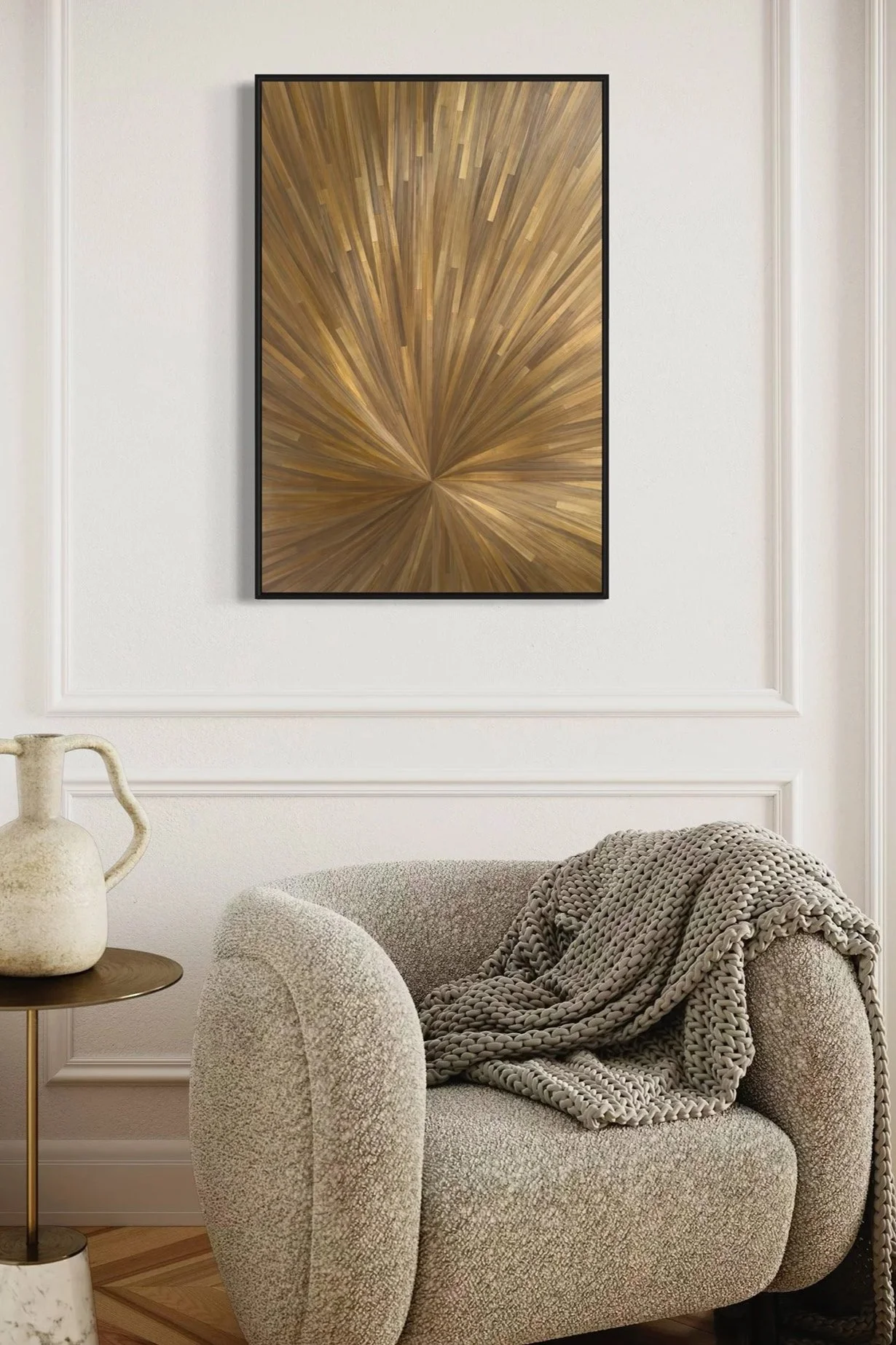 A luminous gold straw marquetry artwork with a striking radial composition, shown above a modern chair. The single-tone palette glows with natural light, highlighting the intricate craftsmanship and subtle movement within the surface. A bold yet refi