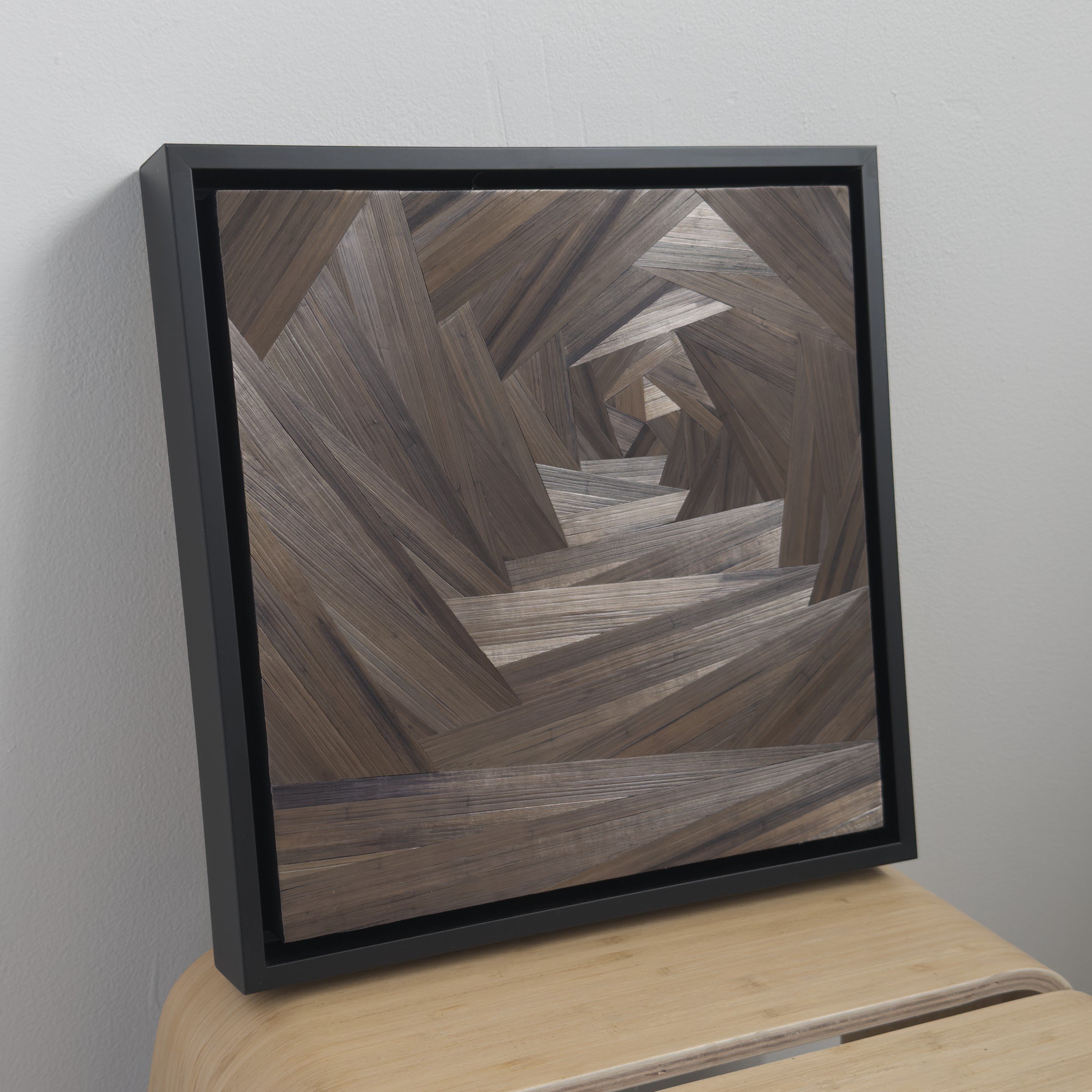 Side profile of What the Cabin Keeps 2 showing black float frame depth and the luminosity of the straw marquetry surface