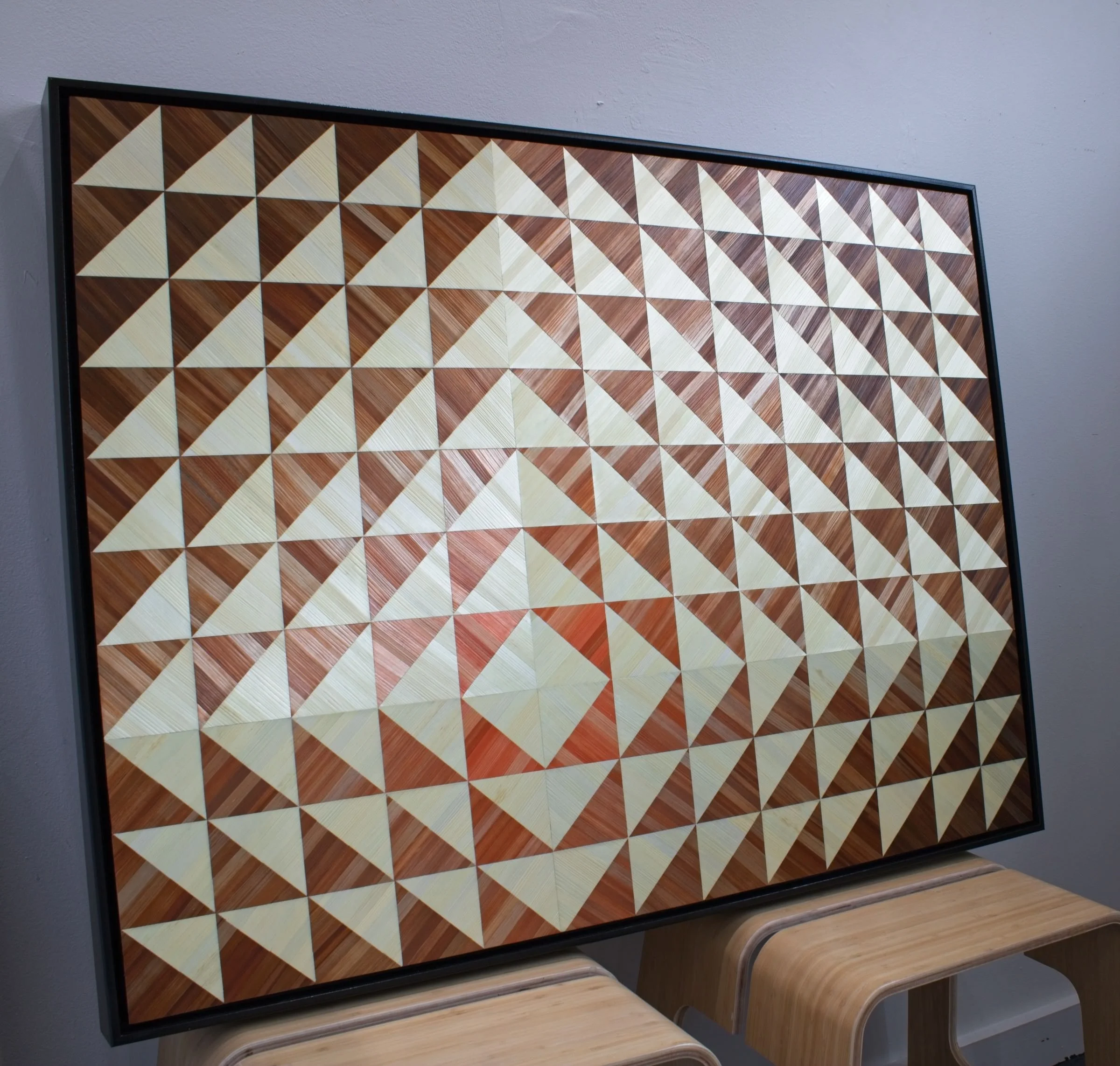 Side profile of float-framed straw marquetry panel showing depth of black frame and luminous, textured straw surface