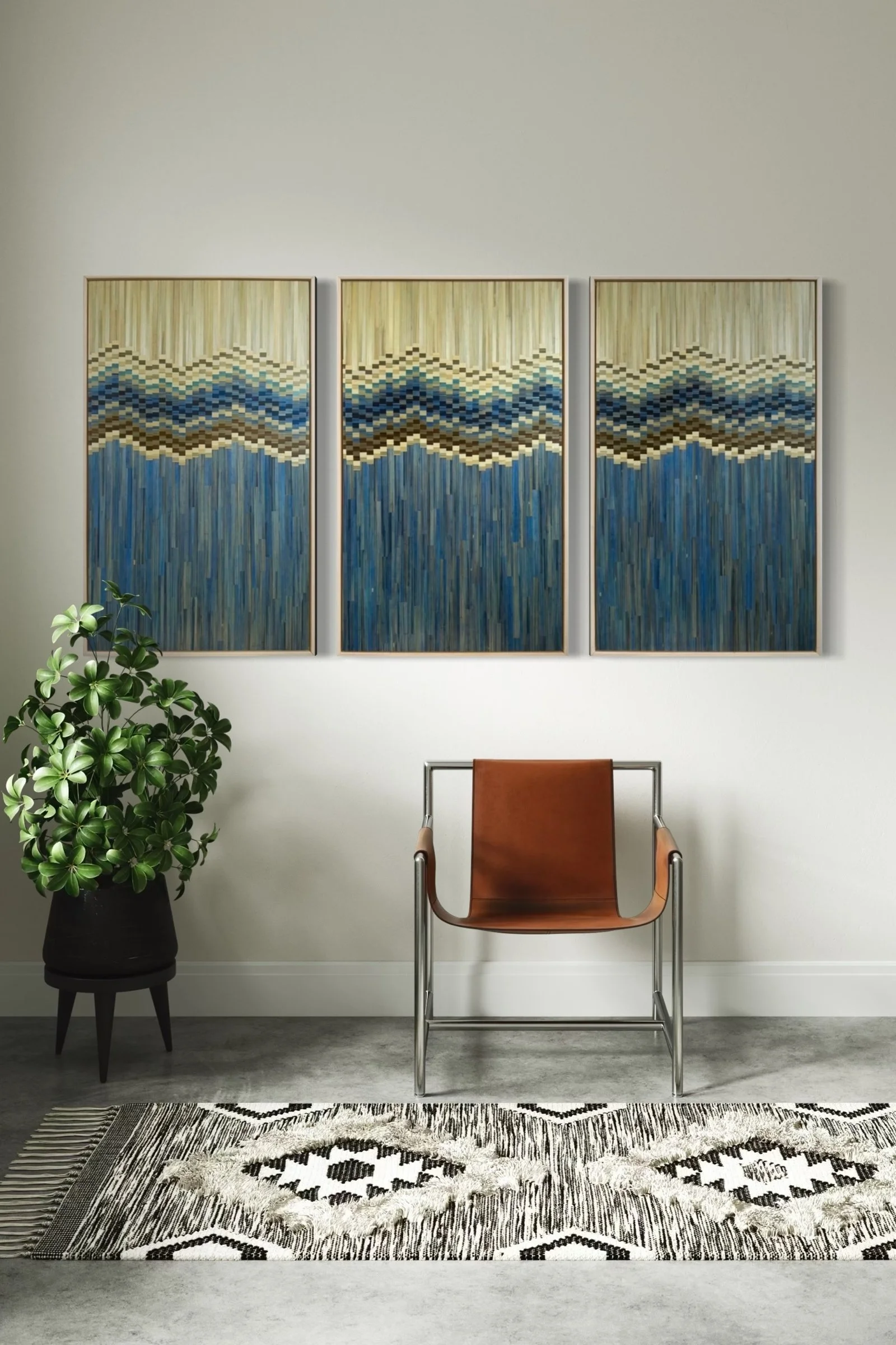 Hand-dyed straw marquetry triptych in creamy beige and blue, with a wave-like pattern that blends from sandy tones at the top into deep ocean blue at the bottom, evoking a shoreline. Natural wood float frames. Shown installed in a minimalist interior