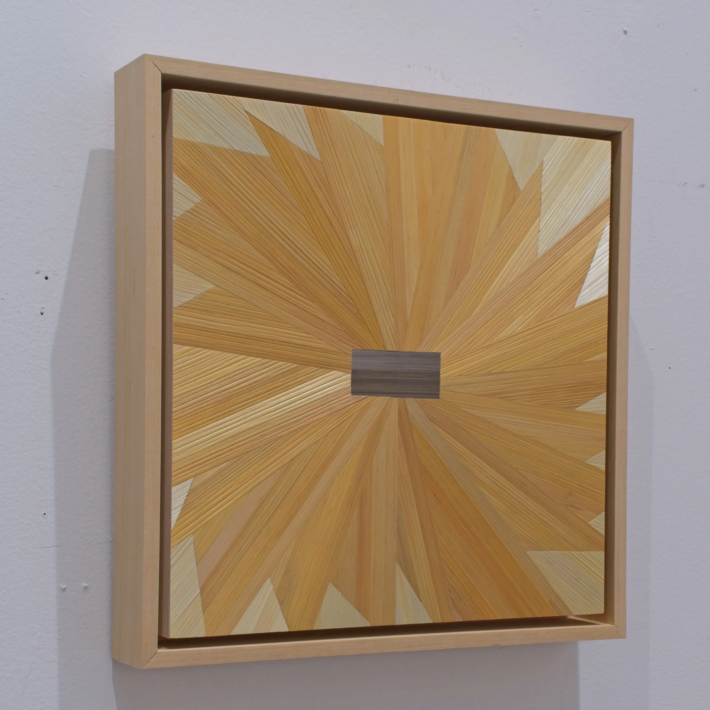 Side profile of a float-framed straw marquetry panel showing maple frame depth; small-format contemporary sunflower fiber art on wood panel