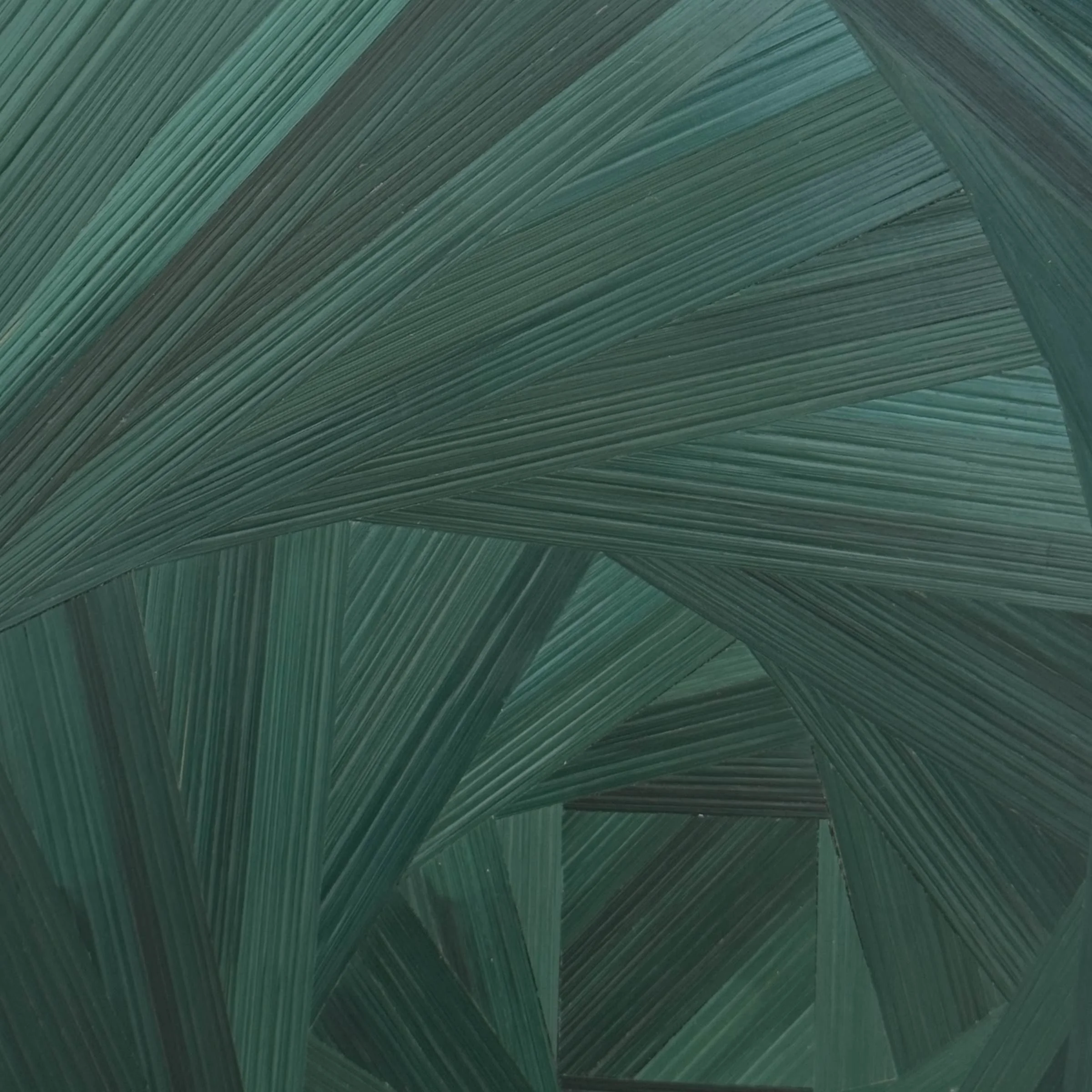 Close-up of hand-laid rye straw marquetry surface showing deep emerald and forest green tones, fine parallel grain of the straw, and the tightening turns of the square spiral pattern