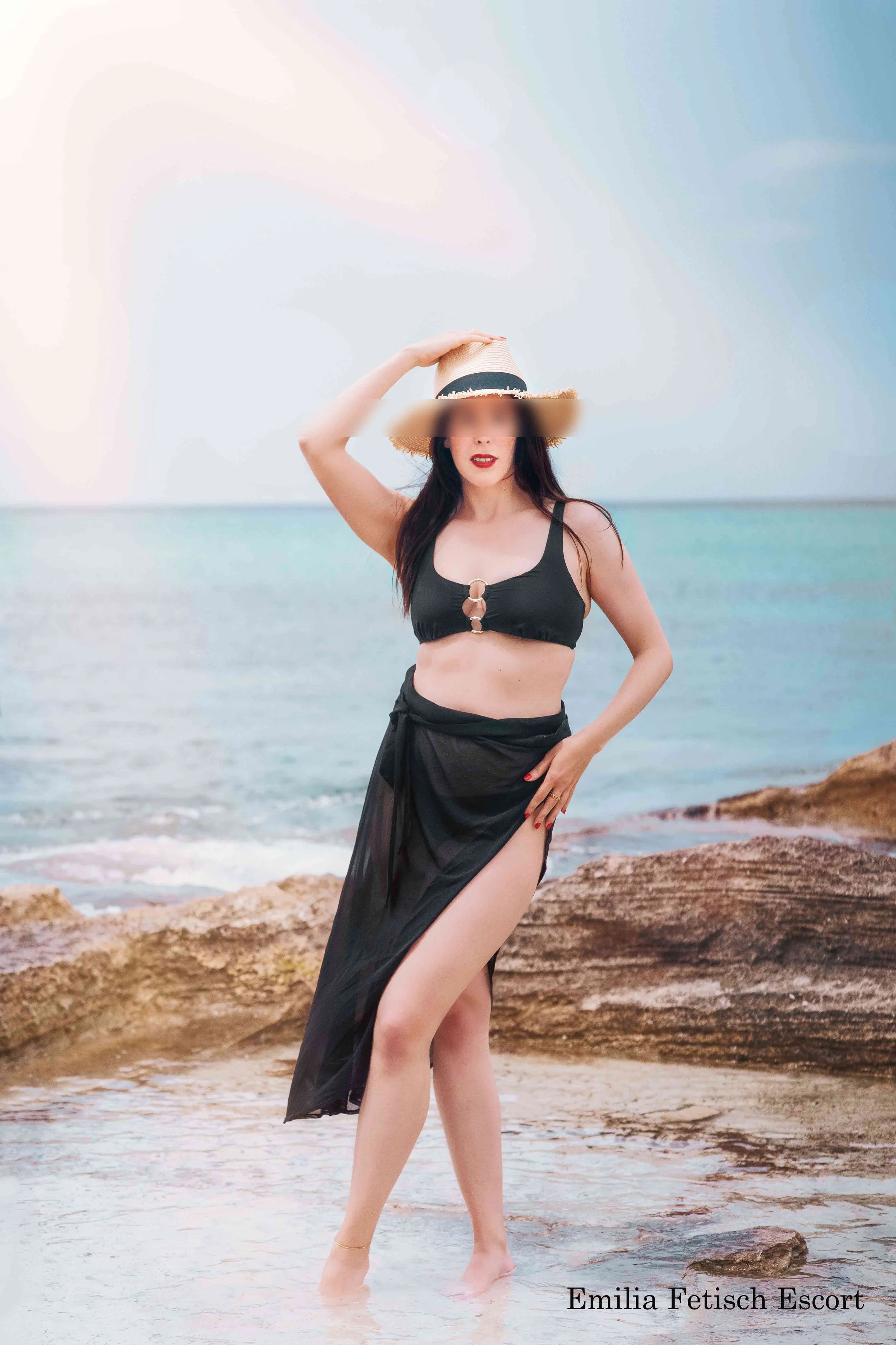 Emilia Schneider am Strand von Mallorca mit Hut.