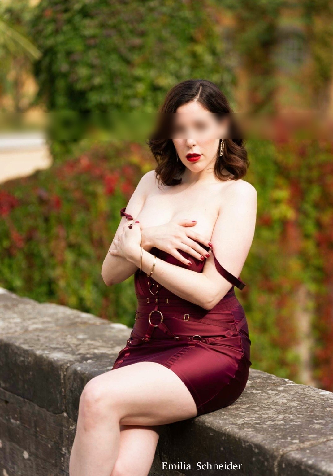 Independent Escort im roten Kleid in einem Garten