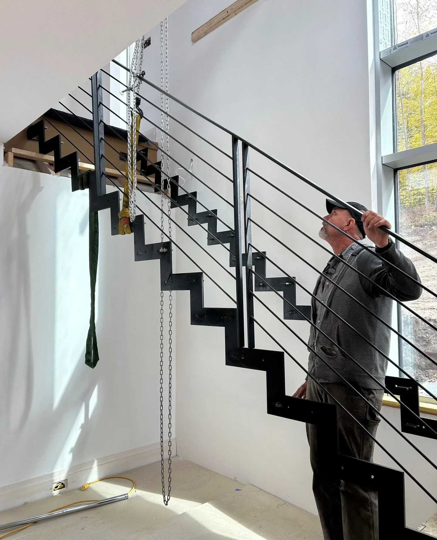 Install day of this stunning steel staircase, crafted by the skilled team at @flywheelindustrialarts. The stair treads are made of white oak&mdash;such a lovely pairing at our Waitsfield Net-zero build.⁠
⁠
#finehomebuilding⁠
#rootsbuildersvt⁠
#net-ze