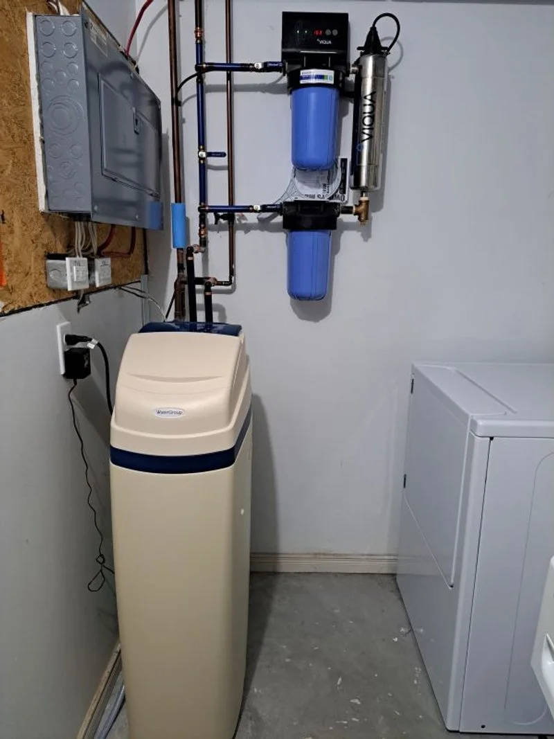 Water treatment system containing a cabinet upflow softener, sediment filter, UV light, and carbon filter.
