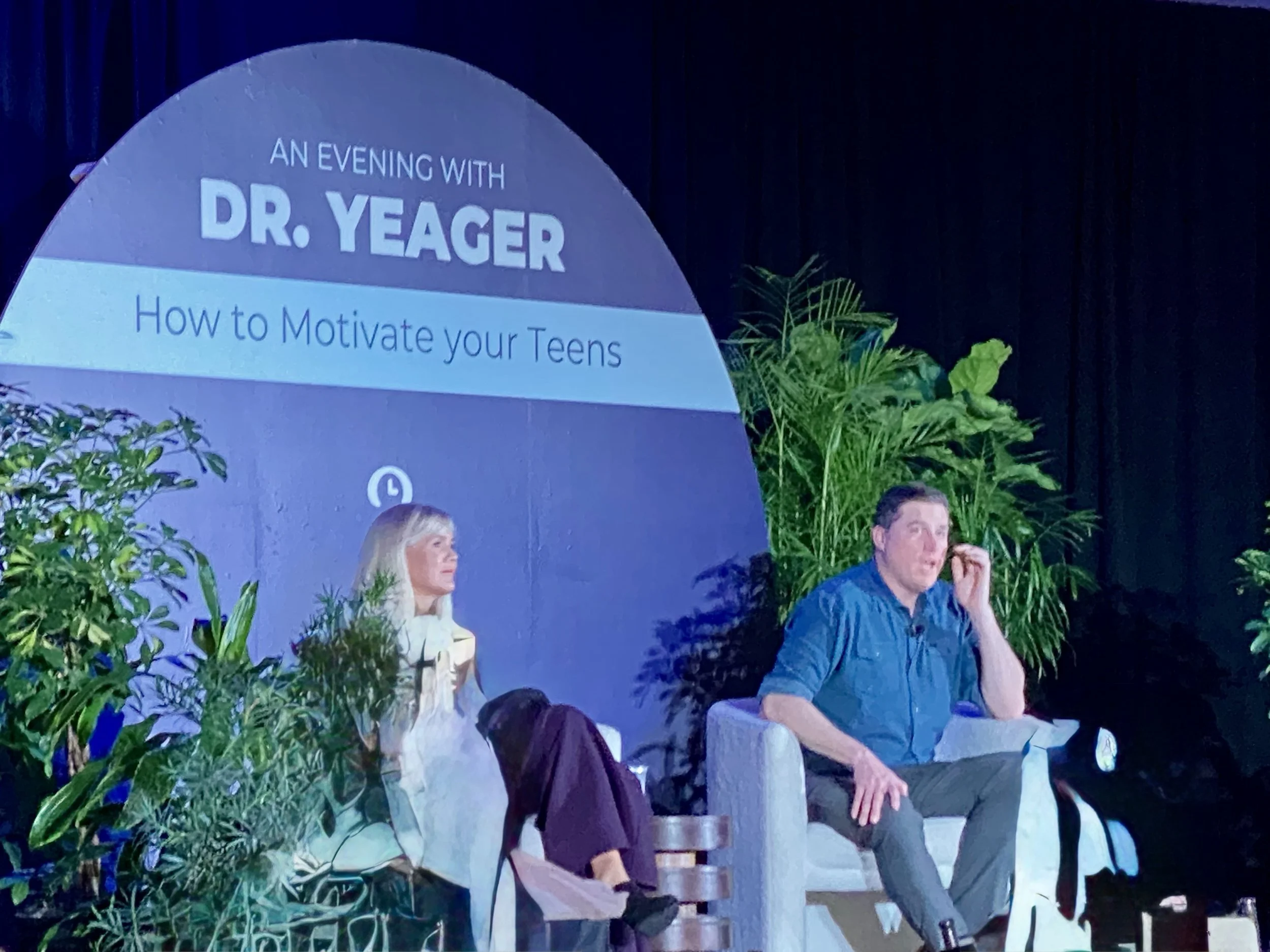 David Yeager speaking on stage at a fireside chat in Austin