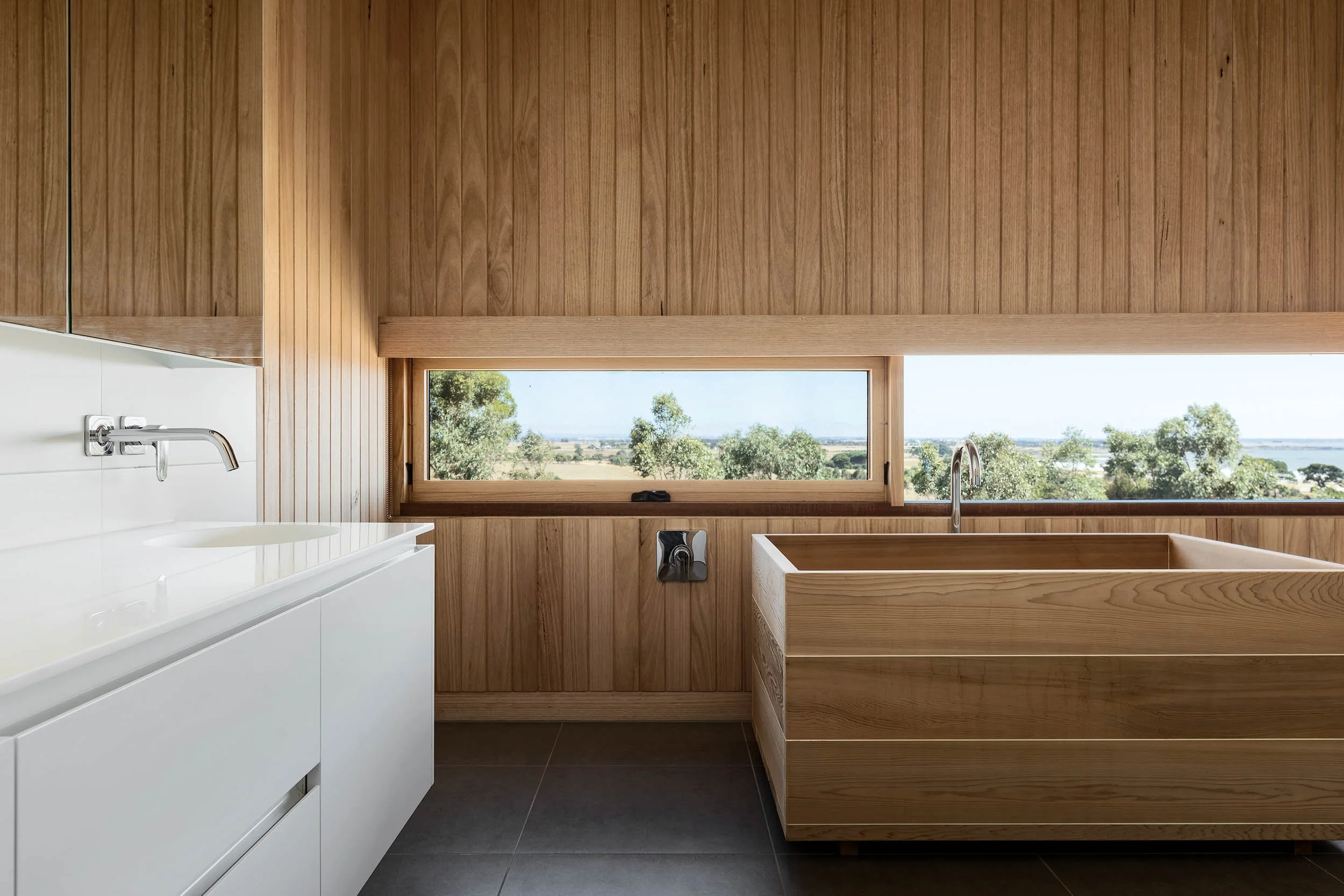 Modern custom-built bathroom with natural wood features and modern finishes. 
