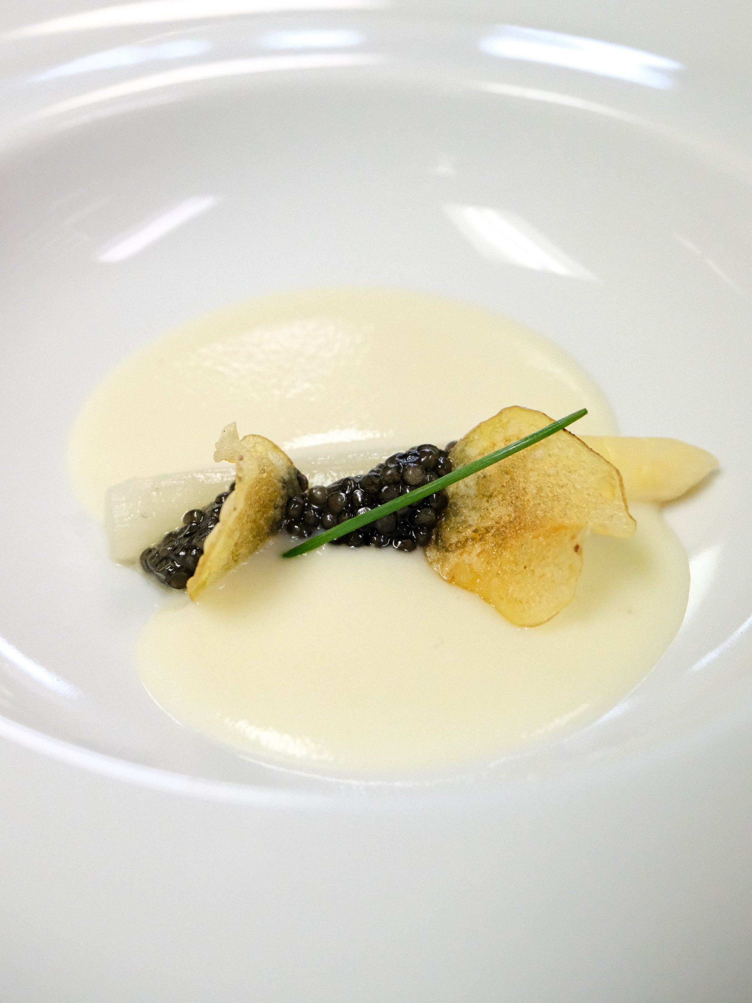a Michelin inspired first course&mdash;amuse bouche. 

chilled potato vichyssoise, jumbo white asparagus, Ostera caviar topped with fresh chives and house-made baby fingerling potato chips