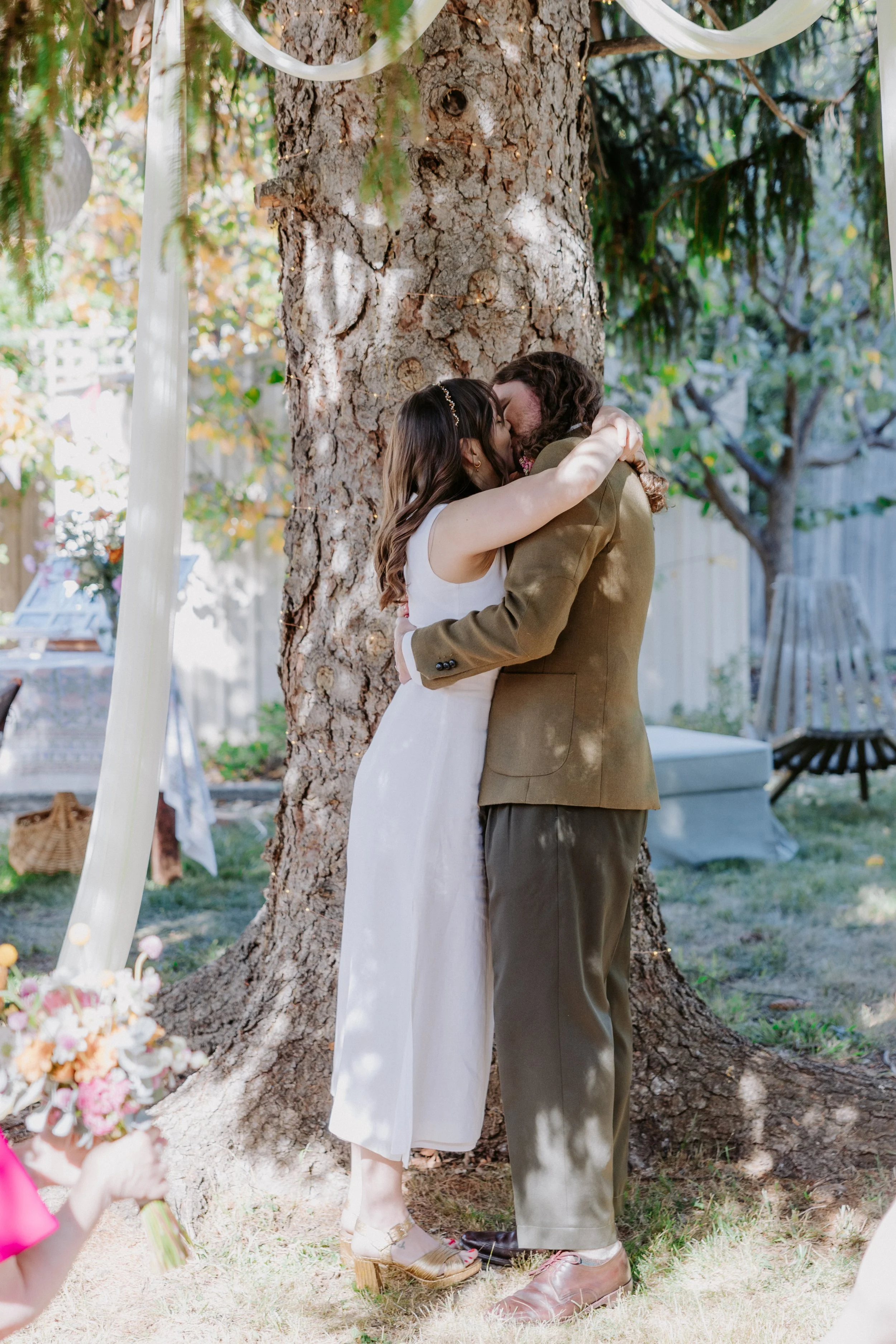 Bride and groom kissing in their backyard