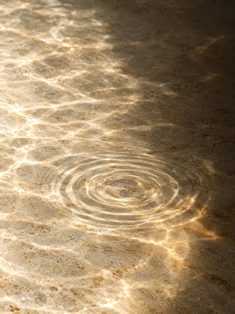 Gentle ripples across water over pale stone.