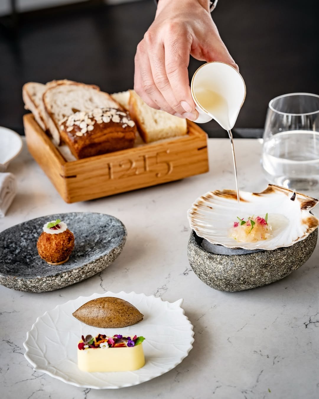 A beautiful trio of dishes at Fairmont Windsor Park, with a bespoke @rewthink bread box in the background; designed, created and engraved for the team at 1215.

Fun fact: did you know that the restaurant's name is a reference to the historic signing 