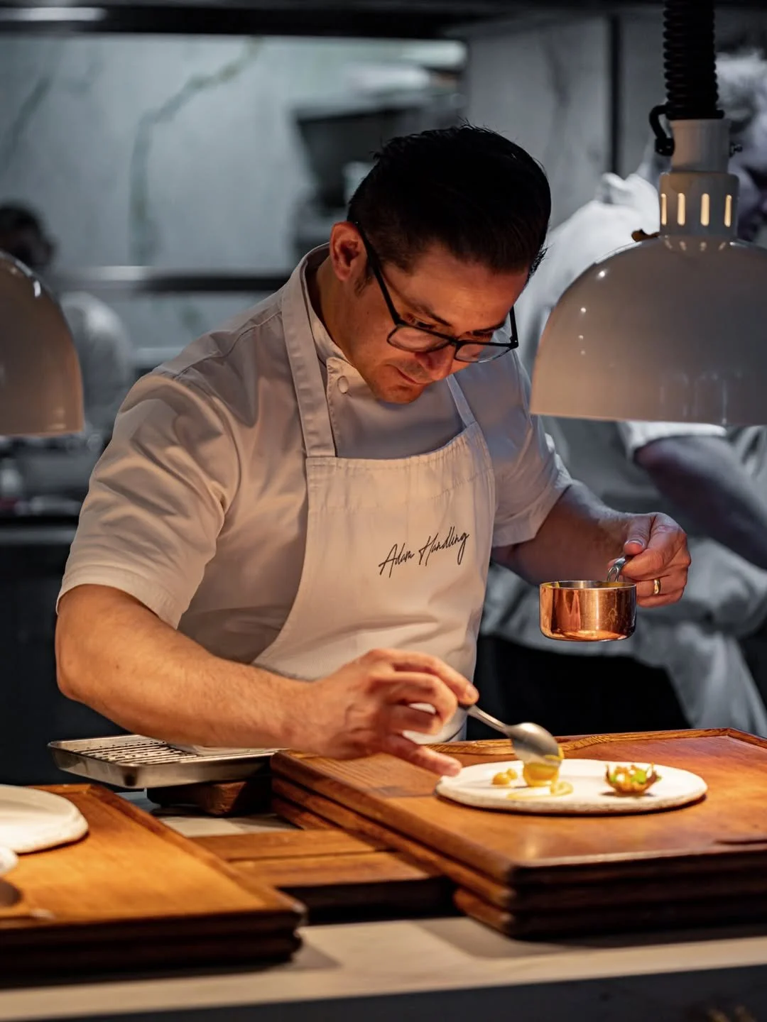 Cleverson Cordeiro adding the final touches at Frog by Adam Handling, with a stack of our classic oak @rewthink trays poised and ready for service ✨ 

📸 @frogbyah