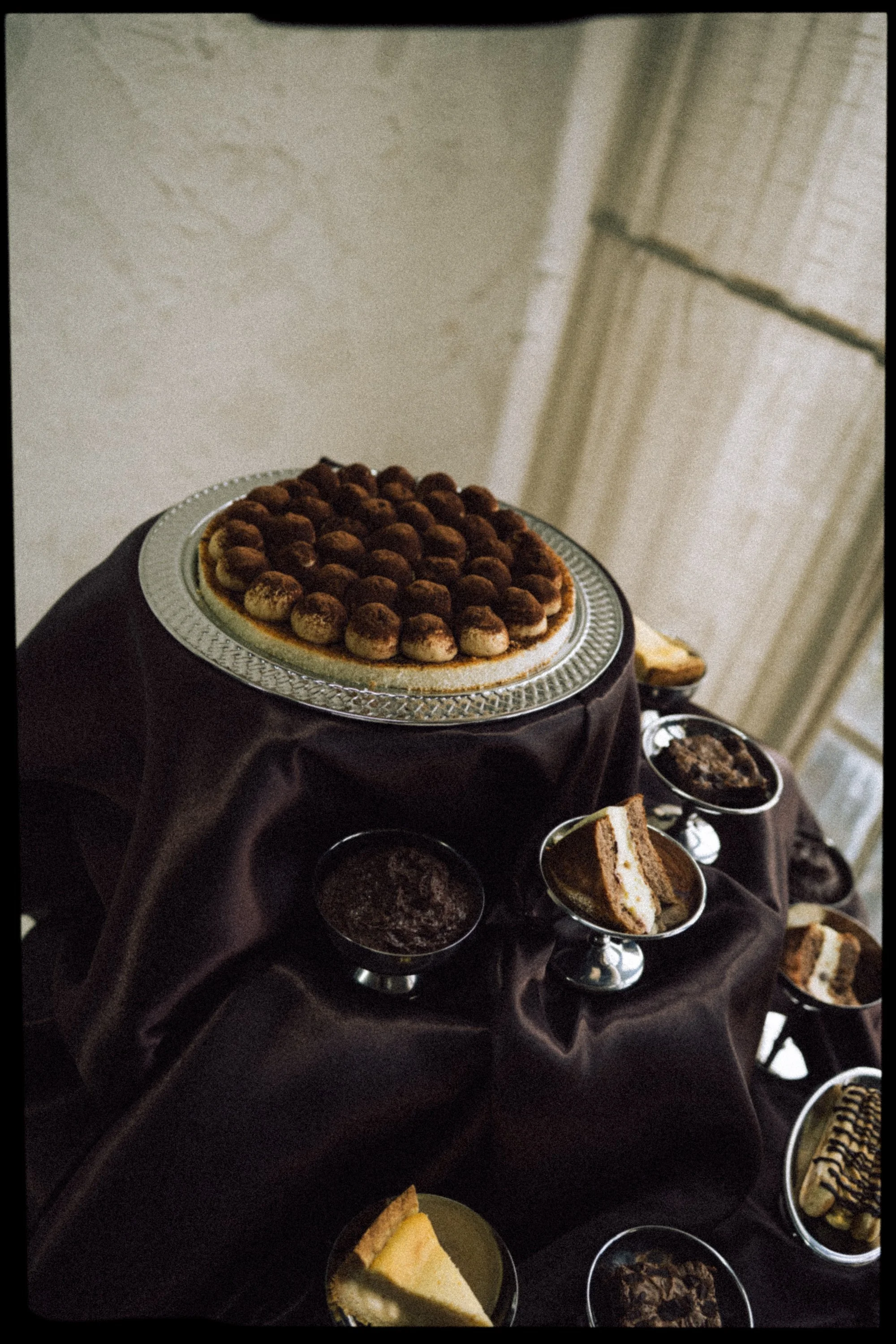 Brown wedding vibes, showing a tiramisu cake on silver plates, served in tonnara de scopello