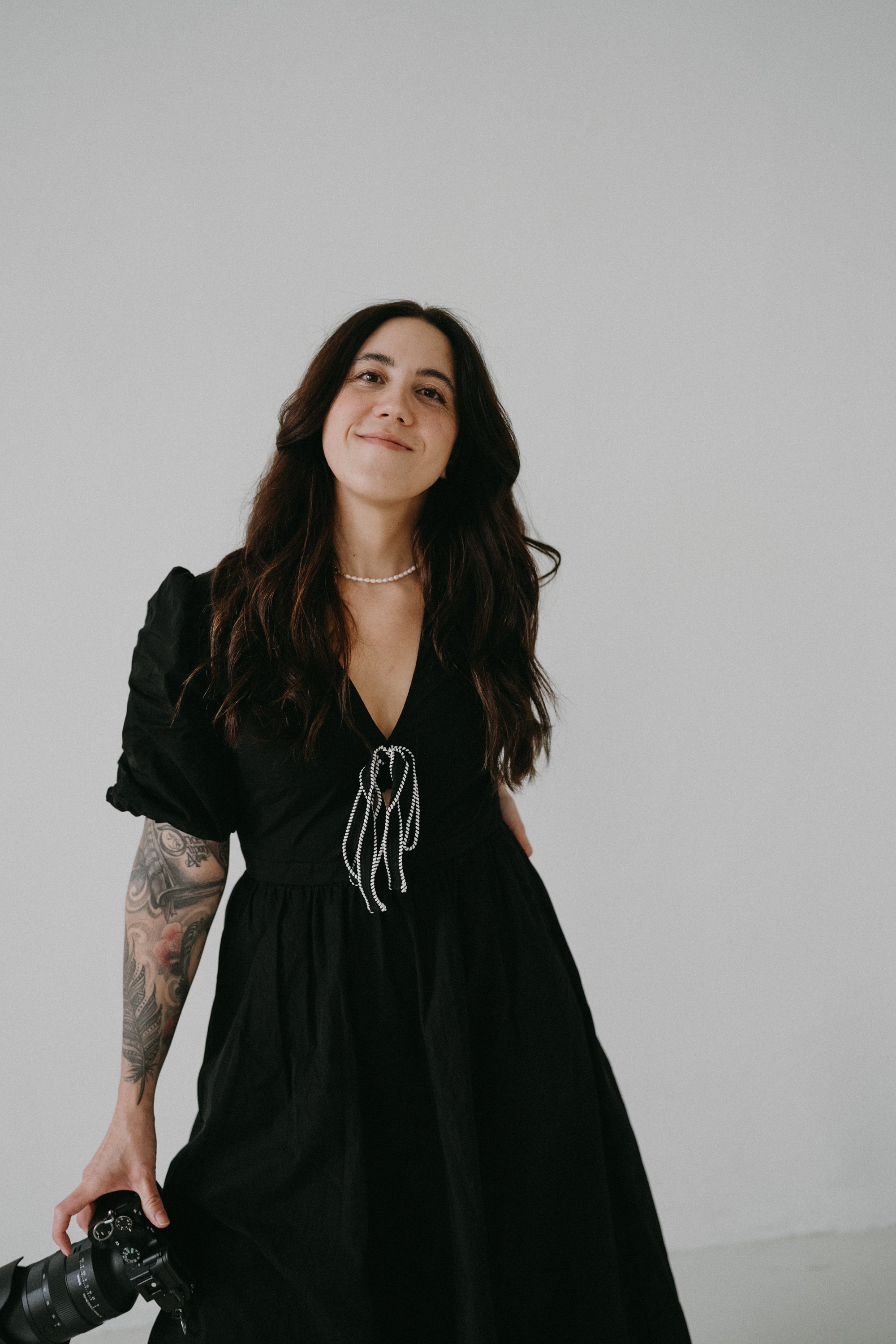Joana Buchmayer smiling at the camera, holding a camera in her right hand