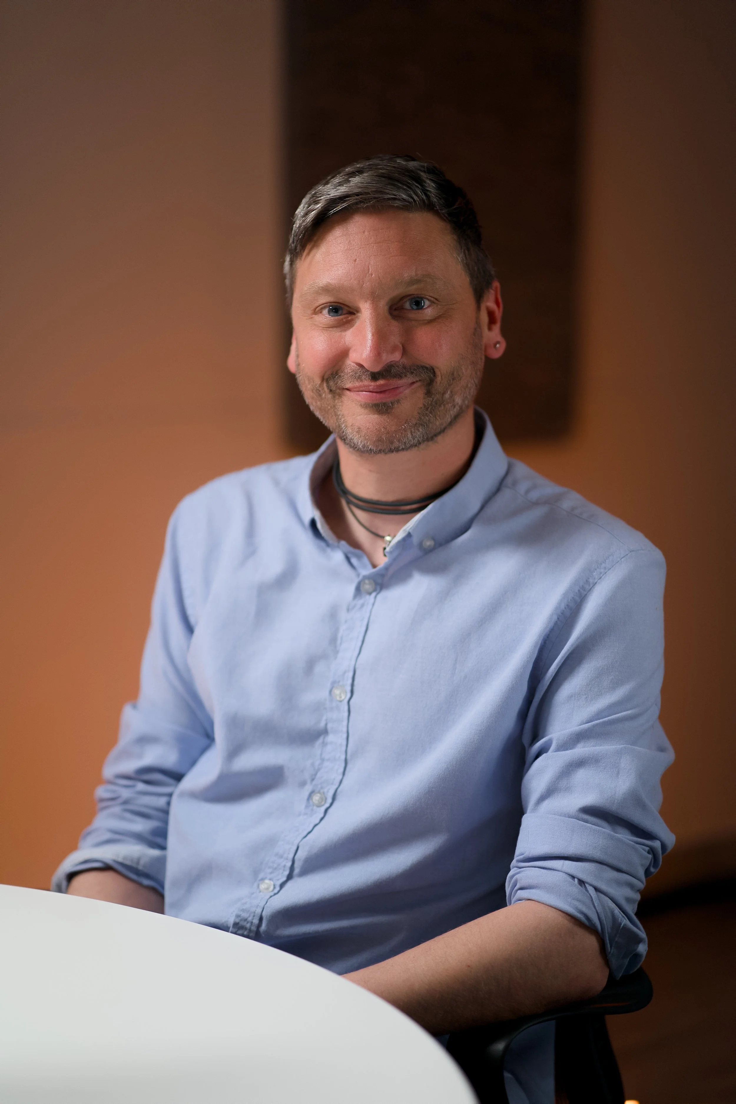 Image of man sitting in chair looking at camera and smiling