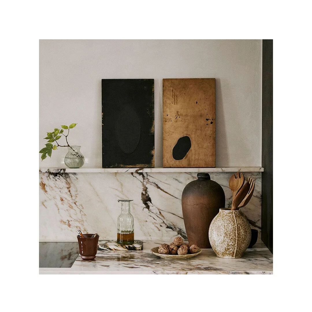 A rich, warm, and nutty countertopscape by interior stylist @colinking. Understated artwork, oversized pottery, and caramel and cocoa veined marble create a luxurious yet cozy atmosphere. The combination of materials adds a subtle richness to this ki