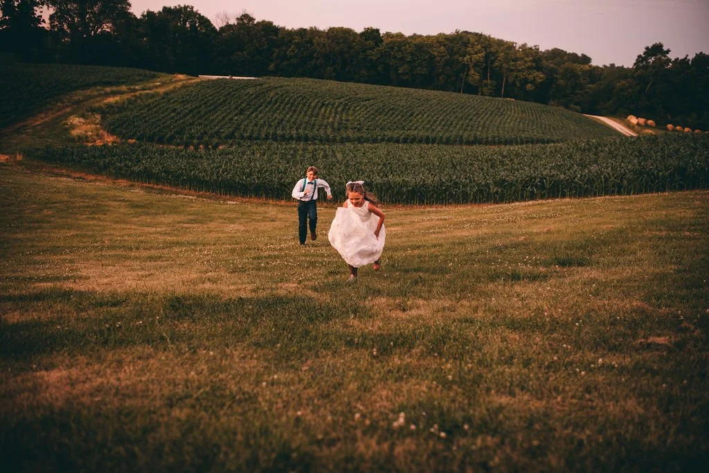 flower girl running at rustic wedding 