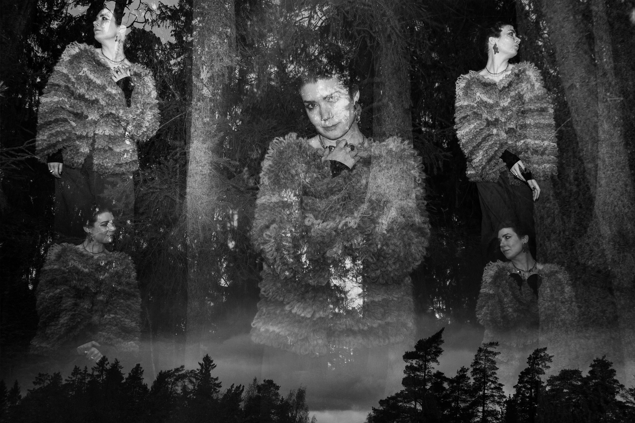 A black and white double exposure photograph of a woman in a fuzzy coat, with trees and a lake in the background.