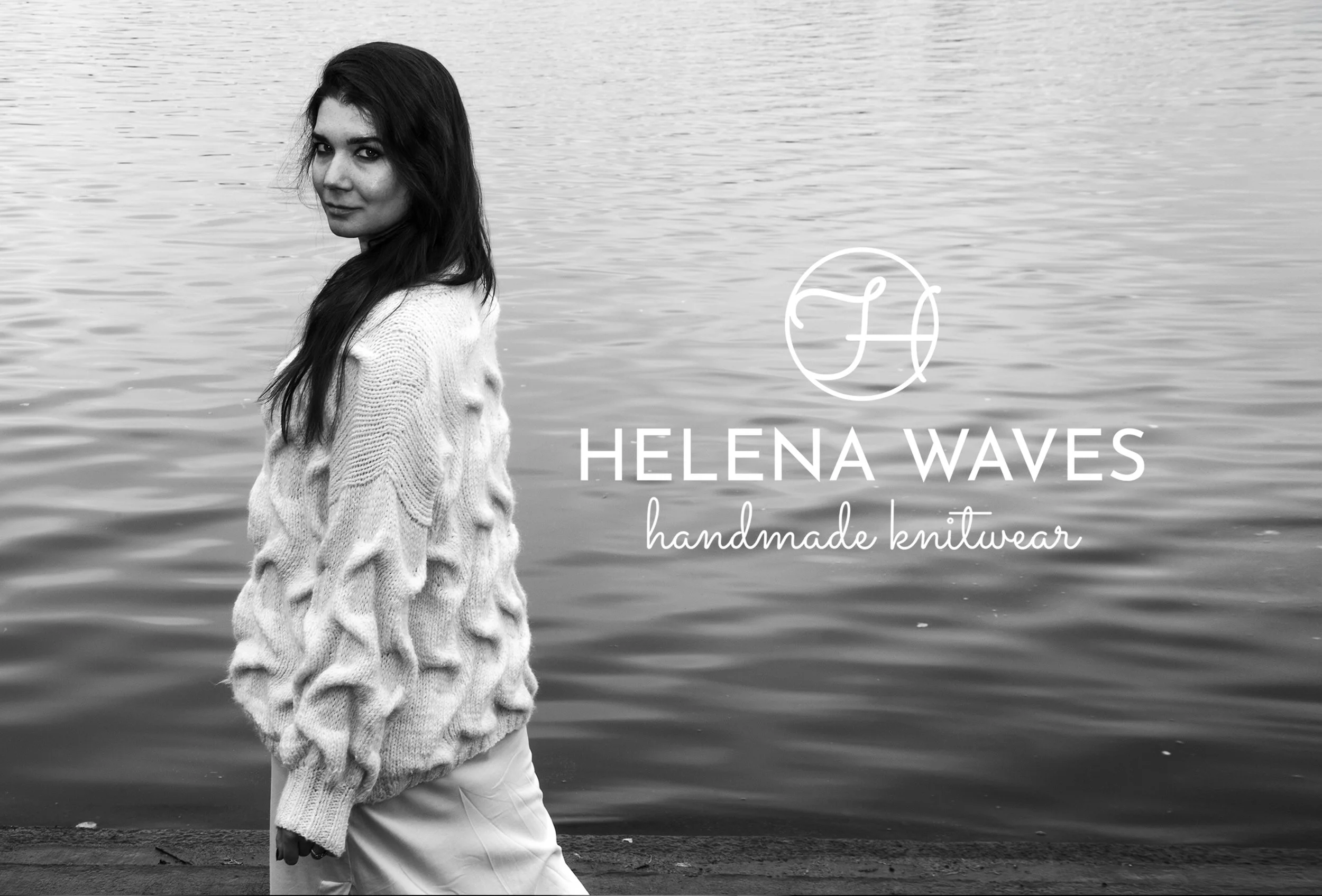 A woman standing by a body of water, wearing a knit sweater and white pants, smiling softly, with text overlay reading 'Helena Waves handmade knitwear.' Brand and Fashion photography in Helsinki.