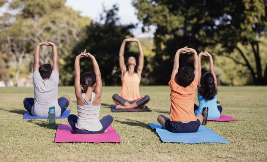 People practicing outdoor yoga in a park setting