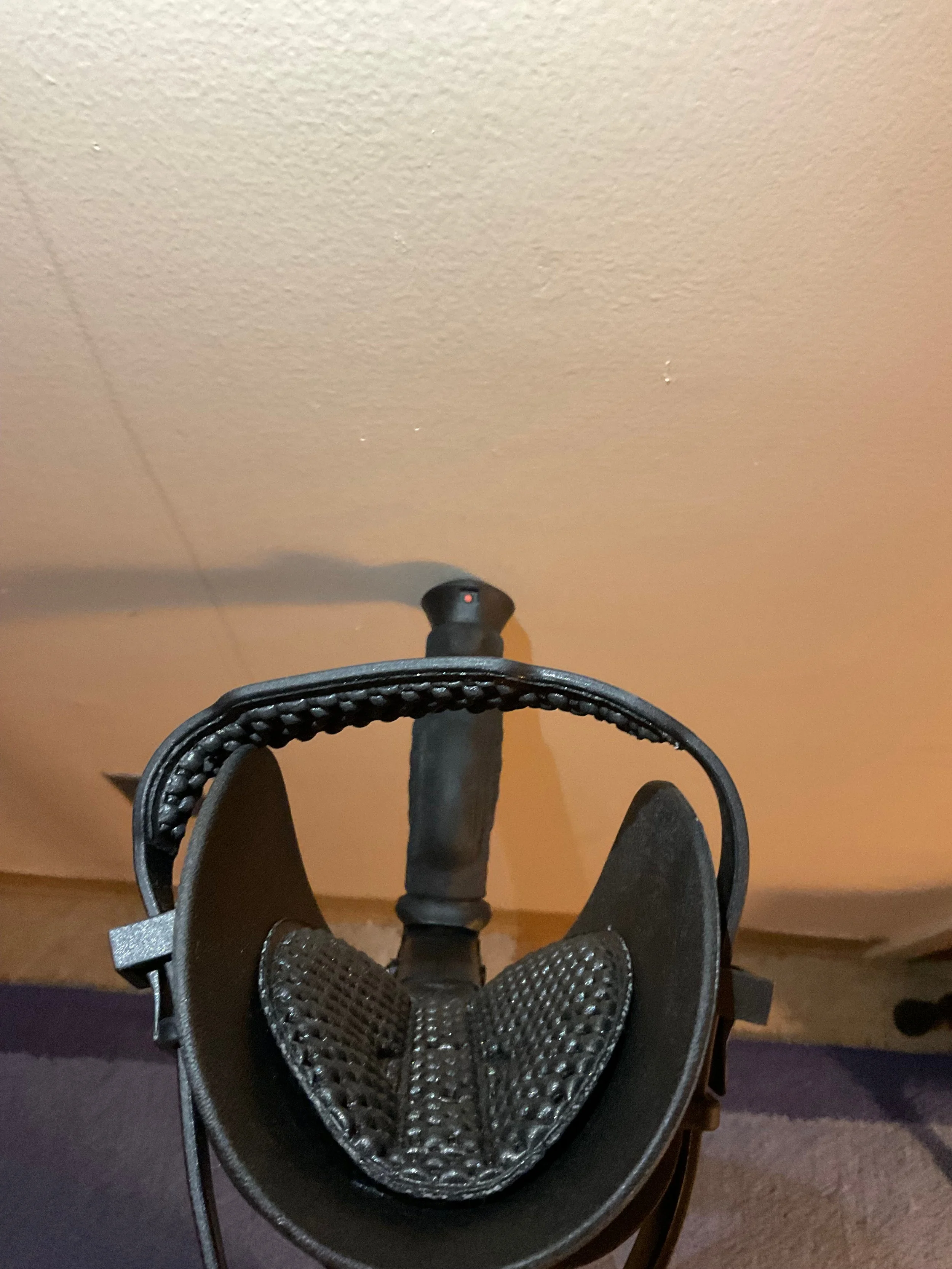   A top-down view of the Ergoactive crutch. The cradle is padded with a bubbly plastic. At the end of the handgrip there is a small red button for the beeper horn.  