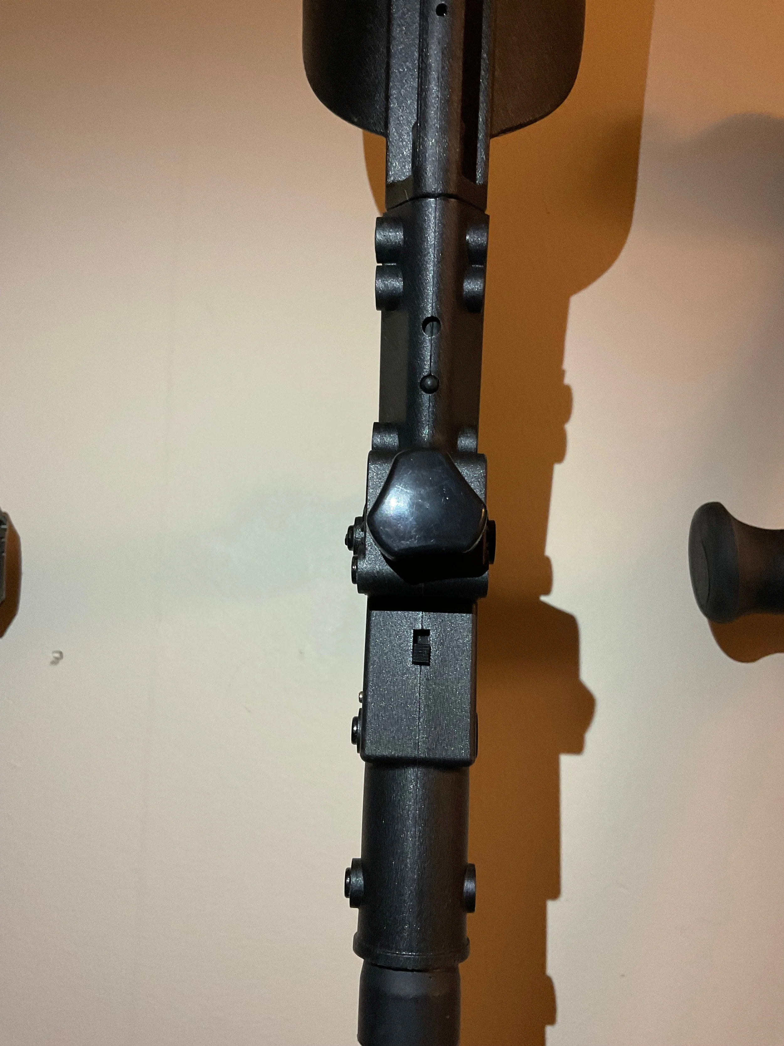A rear view of the Ergoactive crutch at handgrip level. Below the knob that adjusts handgrip angle is a tiny switch to turn on the LED light on the opposite side.