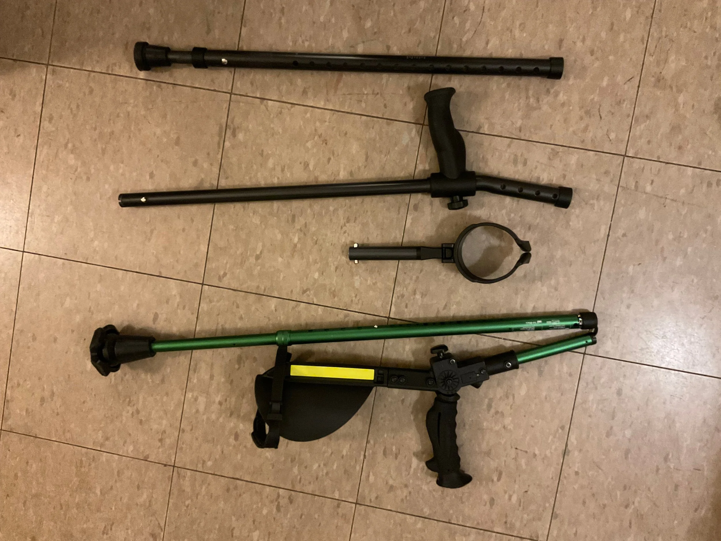 The Millennials and Ergoactives broken down into parts on the ground. The Millennials are in three pieces as the forearm cuff attachment is removed from the shaft with handgrip, and all pieces are shorter than the Ergoactives.
