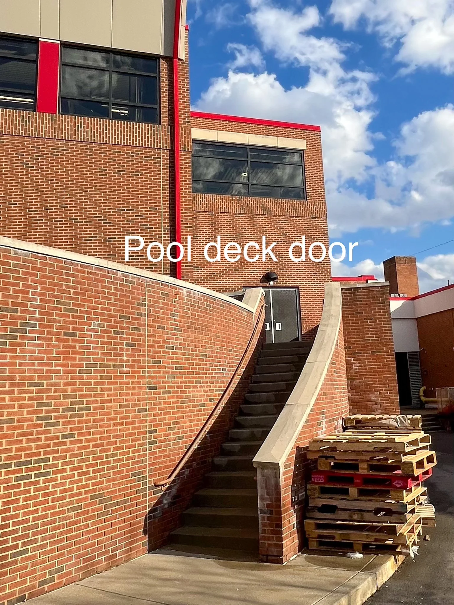 red brick wall and concrete stairs leading up to the door that opens to the Fox Chapel High School pool deck