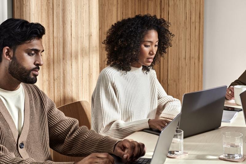 Two people looking at laptops