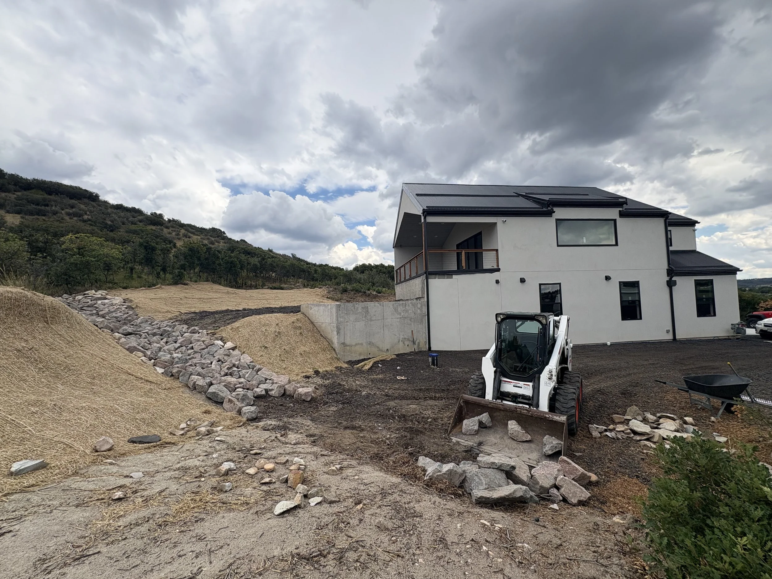 Now Kris begins filling the lower part of the drainage that goes across the driveway.