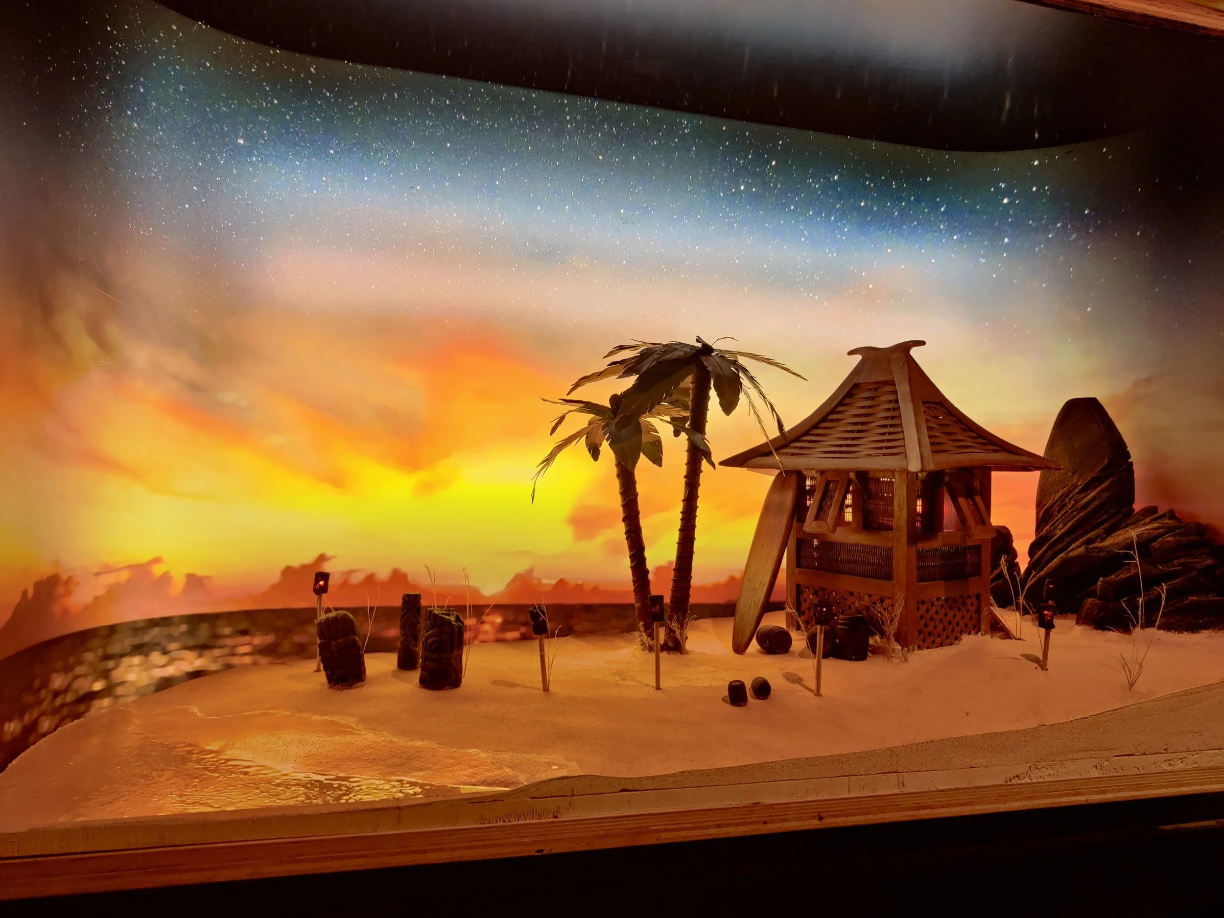 Beach diorama sculpted from HDU. Background painted and lit, LEDs in tiki torches