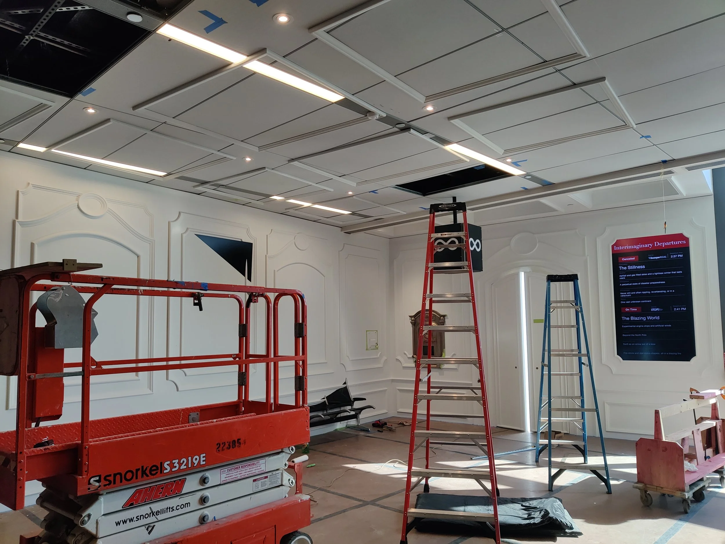 Custom aluminum ceiling moulding installed over existing airport ceiling at 7 degrees off center