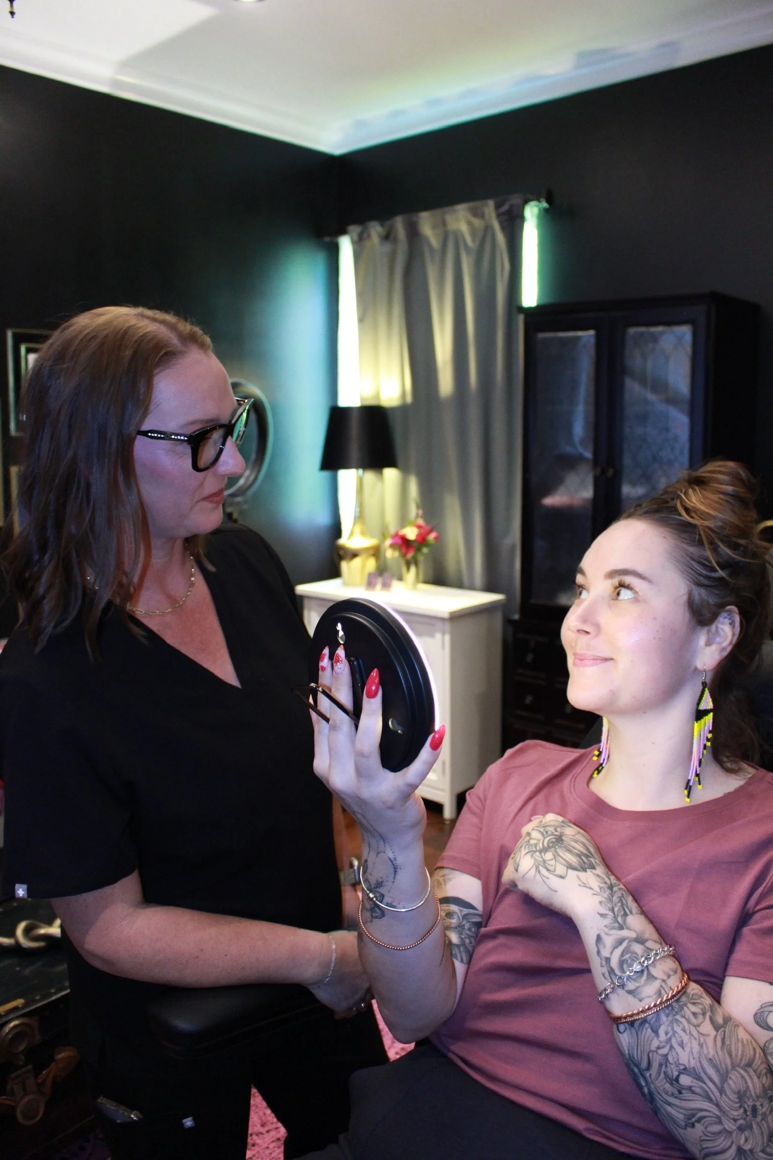 Nurse Hannah with a client, looking at Botox results in our Santa Cruz studio.