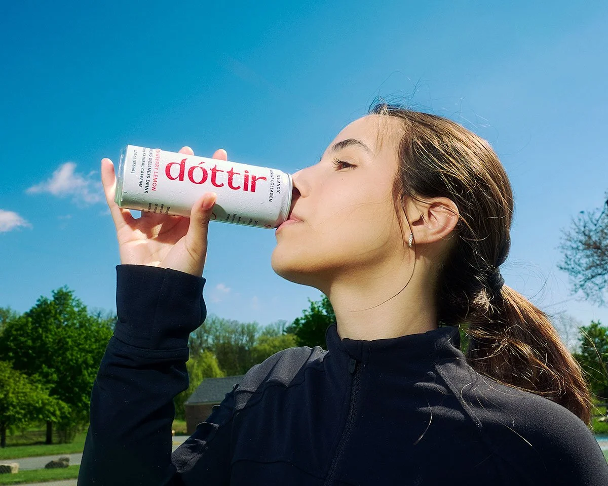Female athlete enjoying a Dóttir Strawberry Lemon collagen wellness drink during the Spring into Summer health and wellness campaign by NAJ Captured