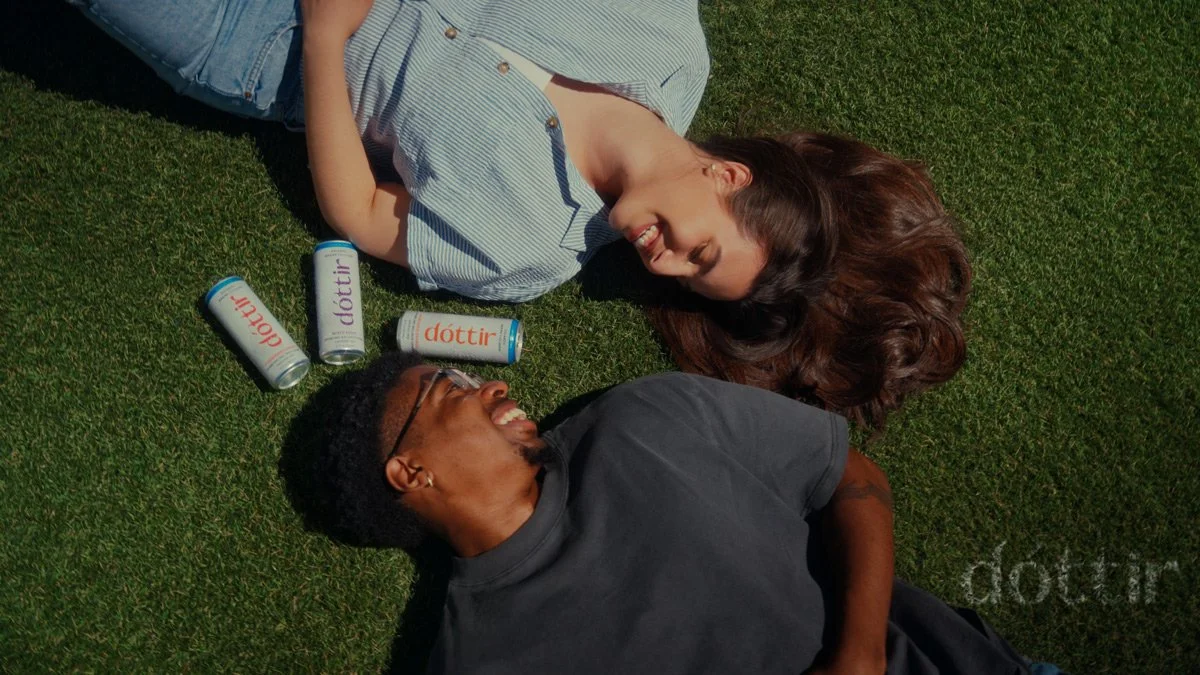Couple relaxing on the grass surrounded by Dóttir collagen wellness drinks during the Spring into Summer lifestyle drink campaign photographed by NAJ Captured in NYC and Pennsylvania.