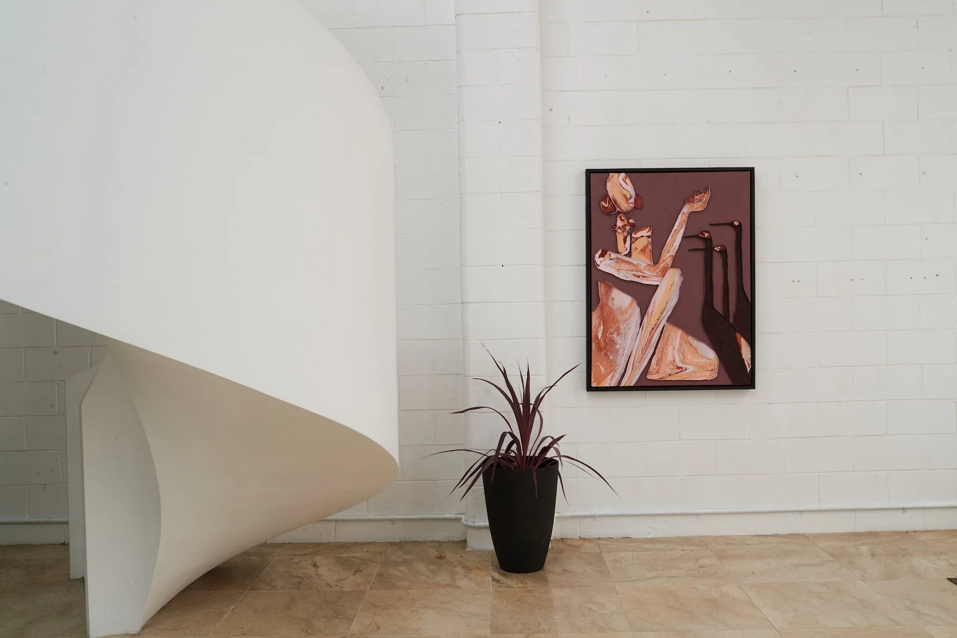 Contemporary art gallery with a white spiral staircase on the left, a potted plant with long, thin leaves in a black pot, and an abstract painting of a reclining female figure on the white brick wall.