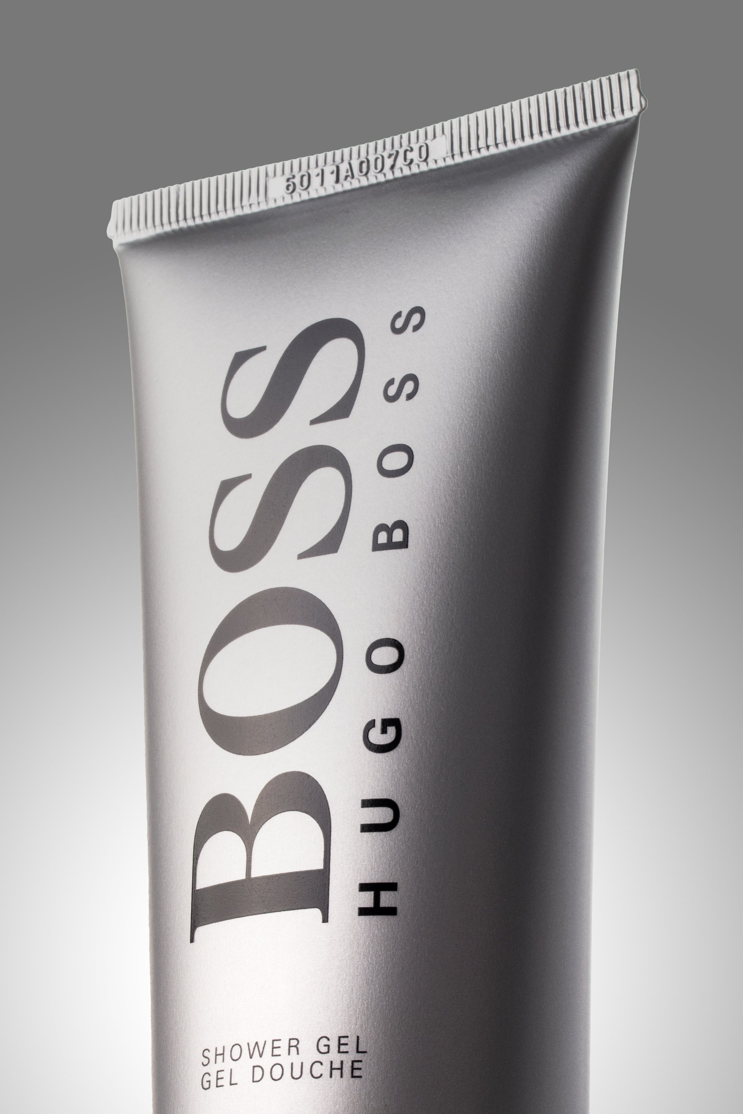 Tube de gel douche Hugo Boss argenté avec texte noir.