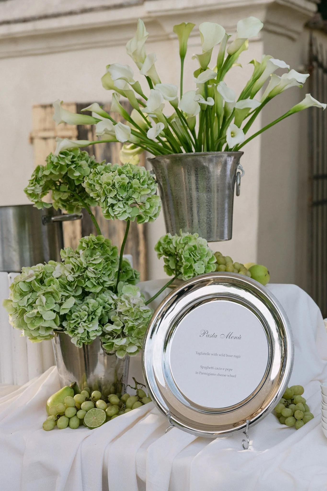 White and green floral arrangements for a Tuscany welcome dinner