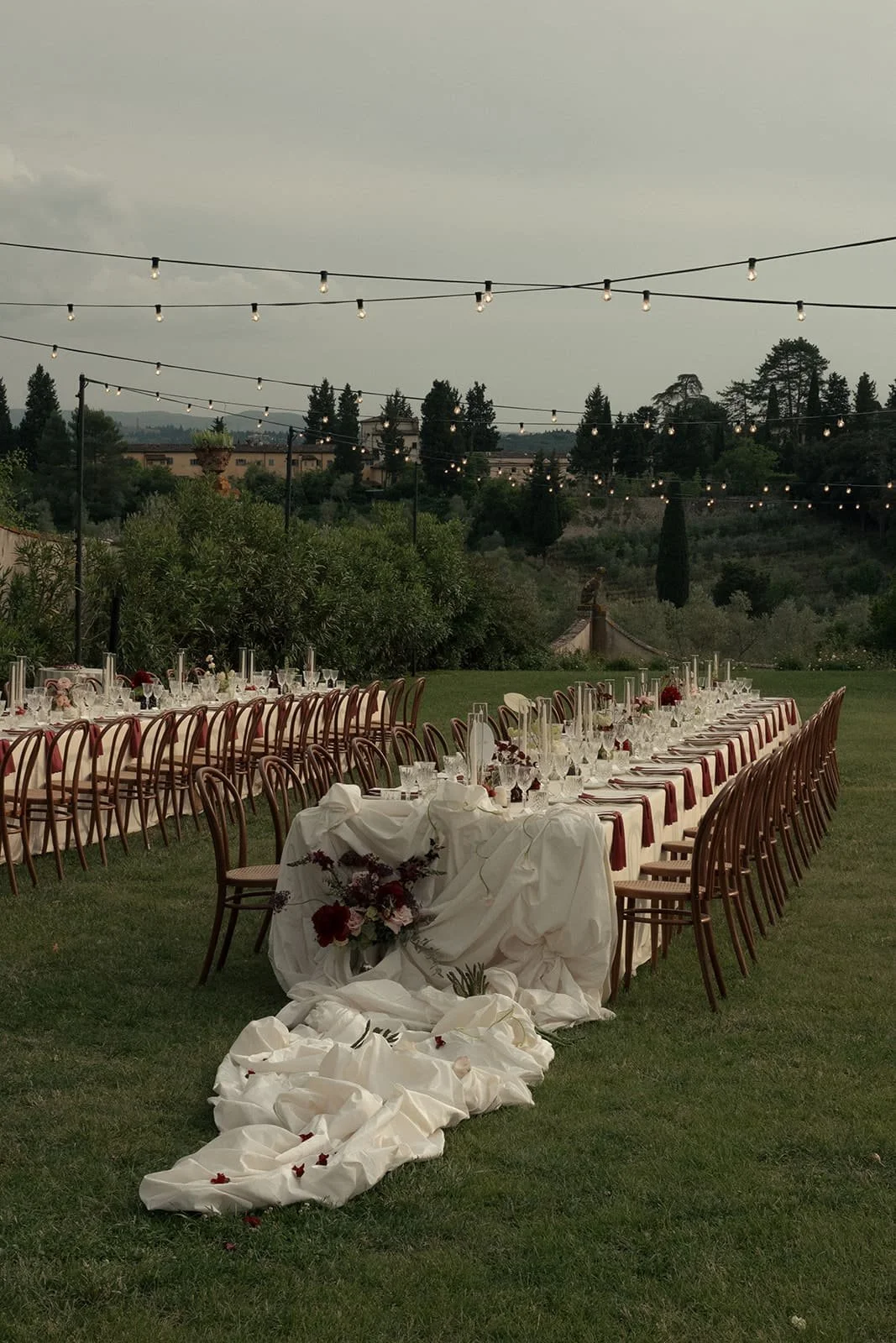 wedding tablescape with a train-like fabric drape extending from the central table