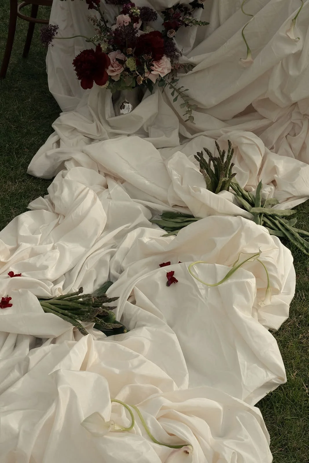 Showstopping central dinner table with flowing fabric and floral arrangements