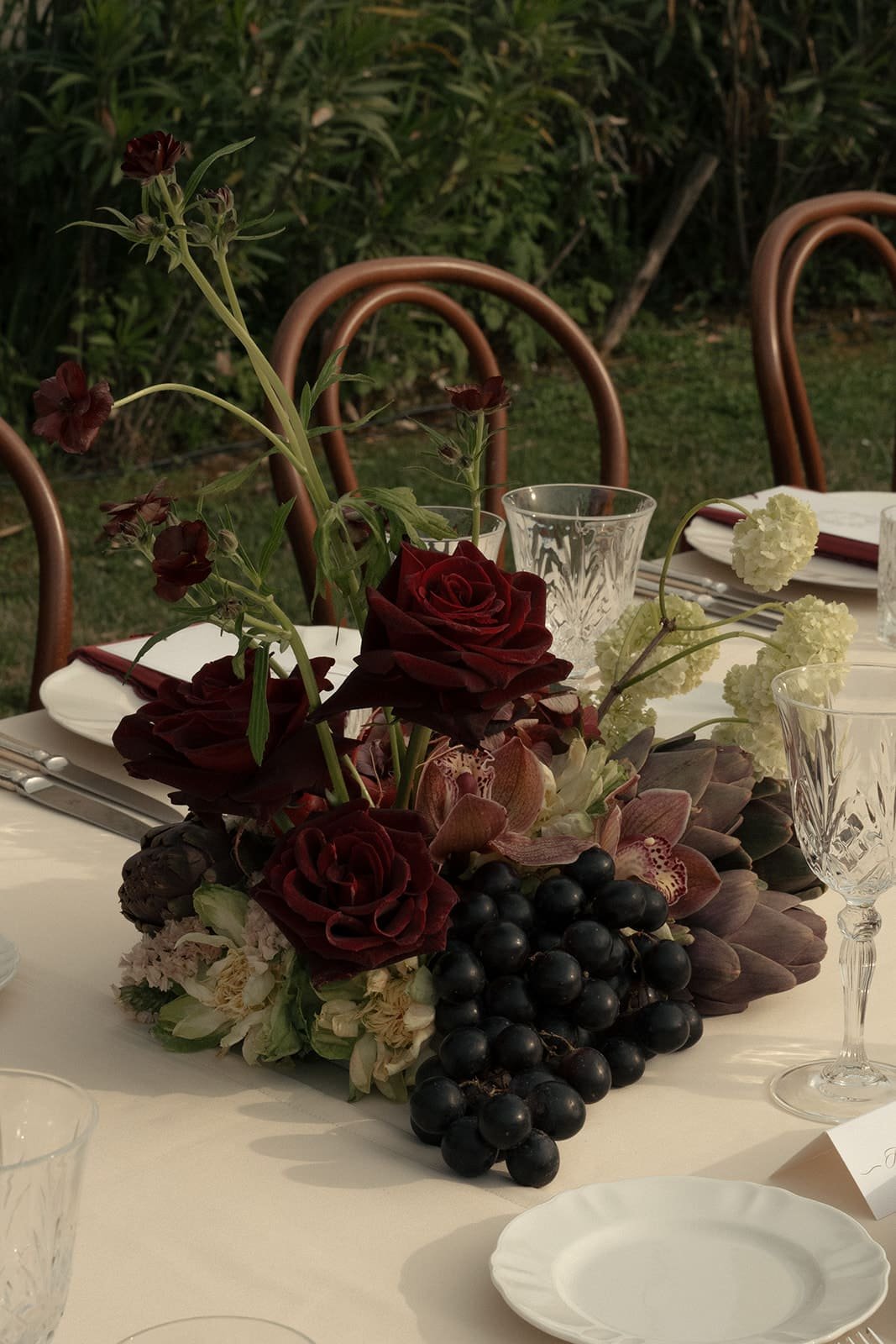 Organic and elegant wedding tablescape featuring flowers, fruit, and vegetables