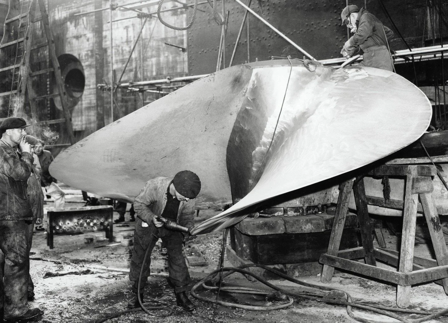 Queen Mary Liner: Workmen scaling one of the four 32 ton propellors during the annual overhaul in a Southampton dry dock on 8th November, 1952. (Photo by Popperfoto via Getty Images/Getty Images)

#photography #history #blackandwhite #ship